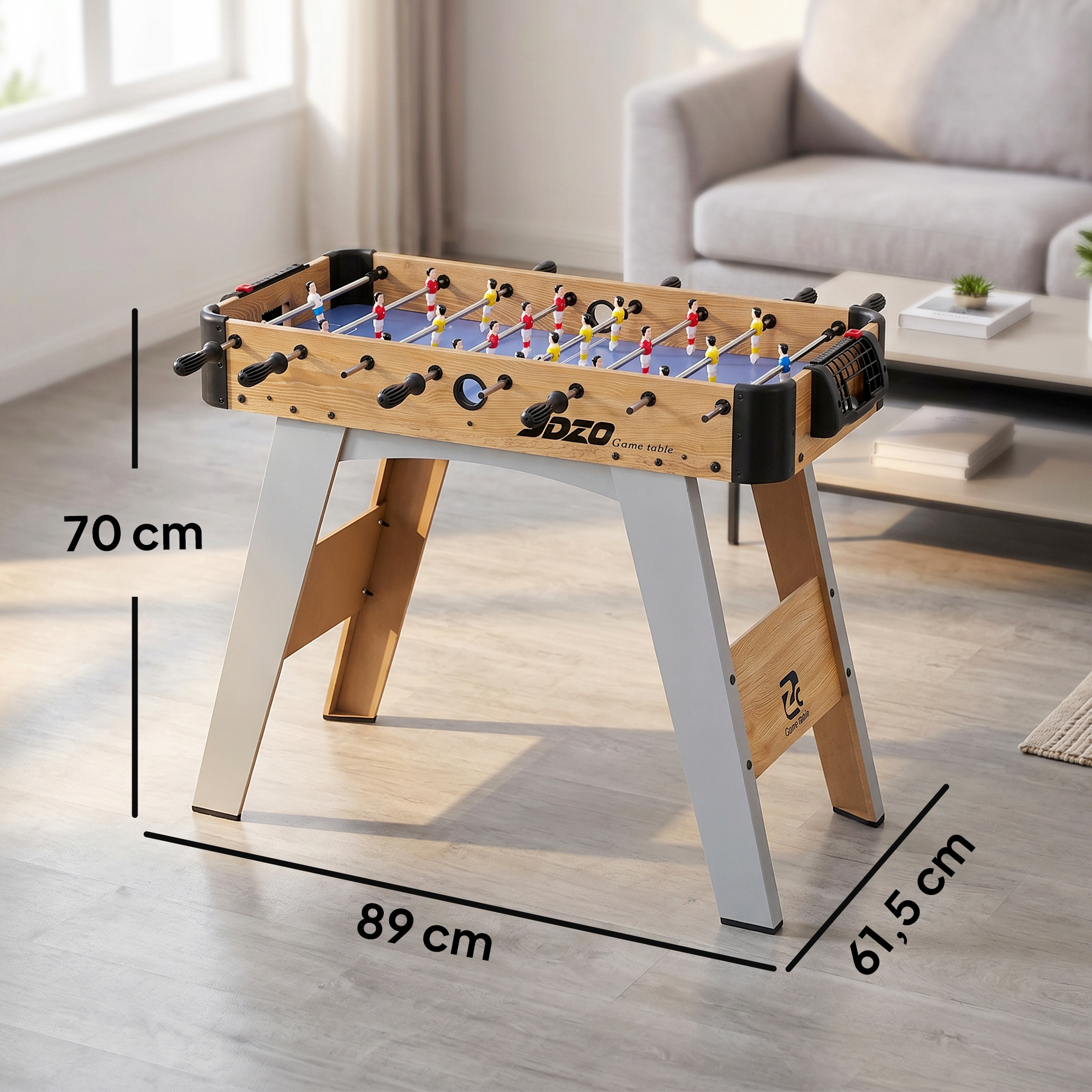 Un futbolín de aspecto madera con dimensiones de 89 cm de largo, 61,5 cm de ancho y 70 cm de alto en una sala.