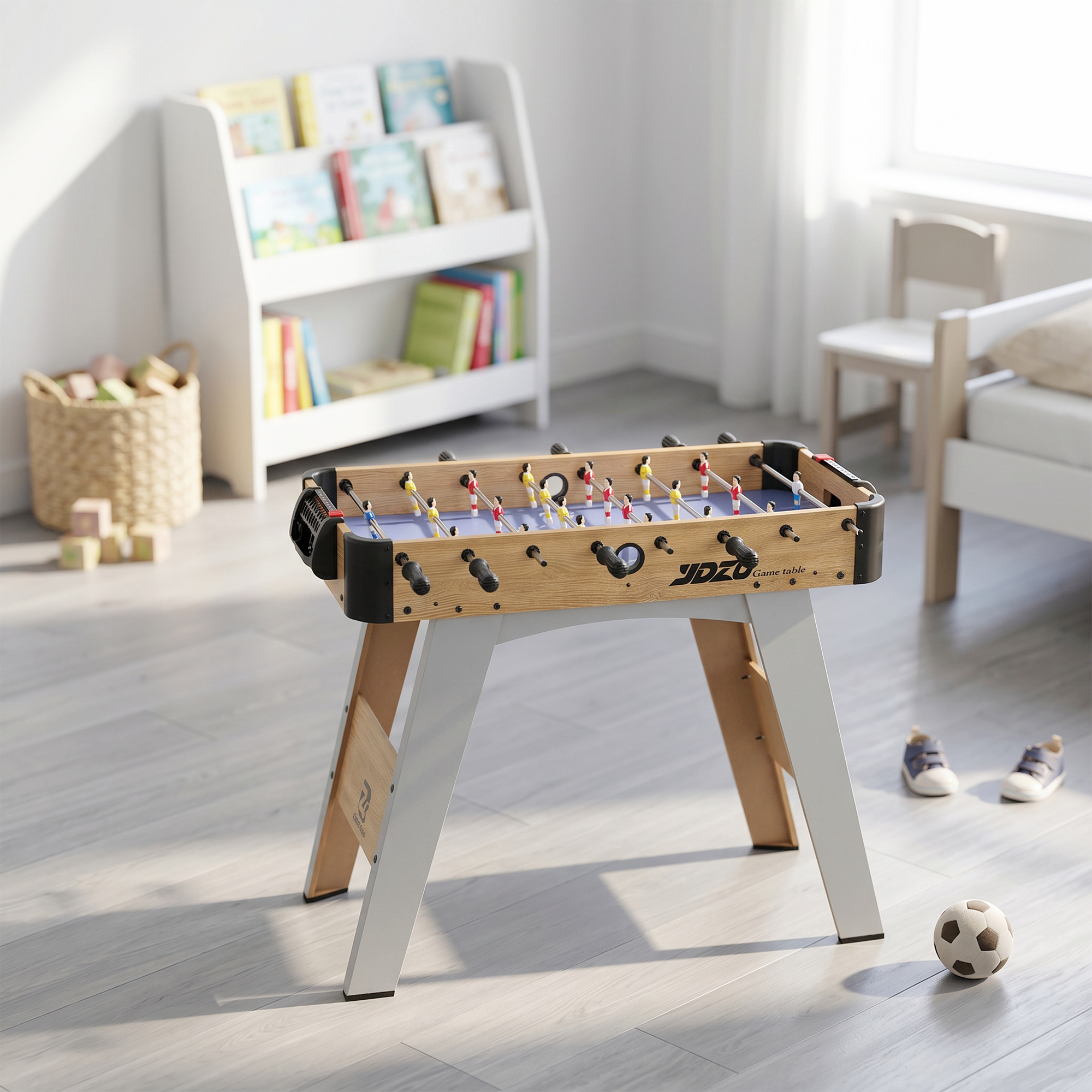 Un futbolín de madera se encuentra en una habitación infantil luminosa. Hay una estantería y juguetes al fondo.