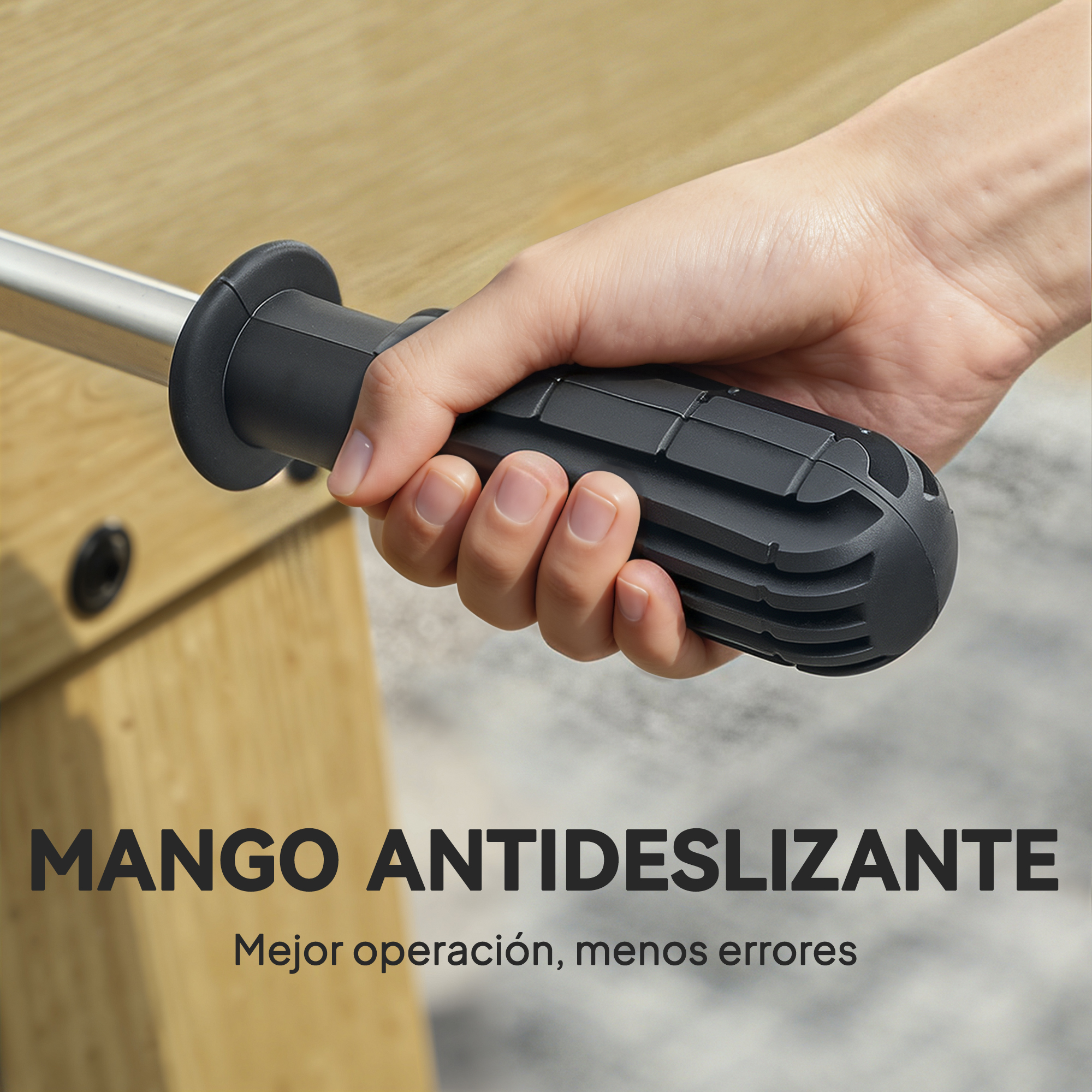 Una mano agarra el mango negro acanalado de un futbolín junto a una mesa de madera.