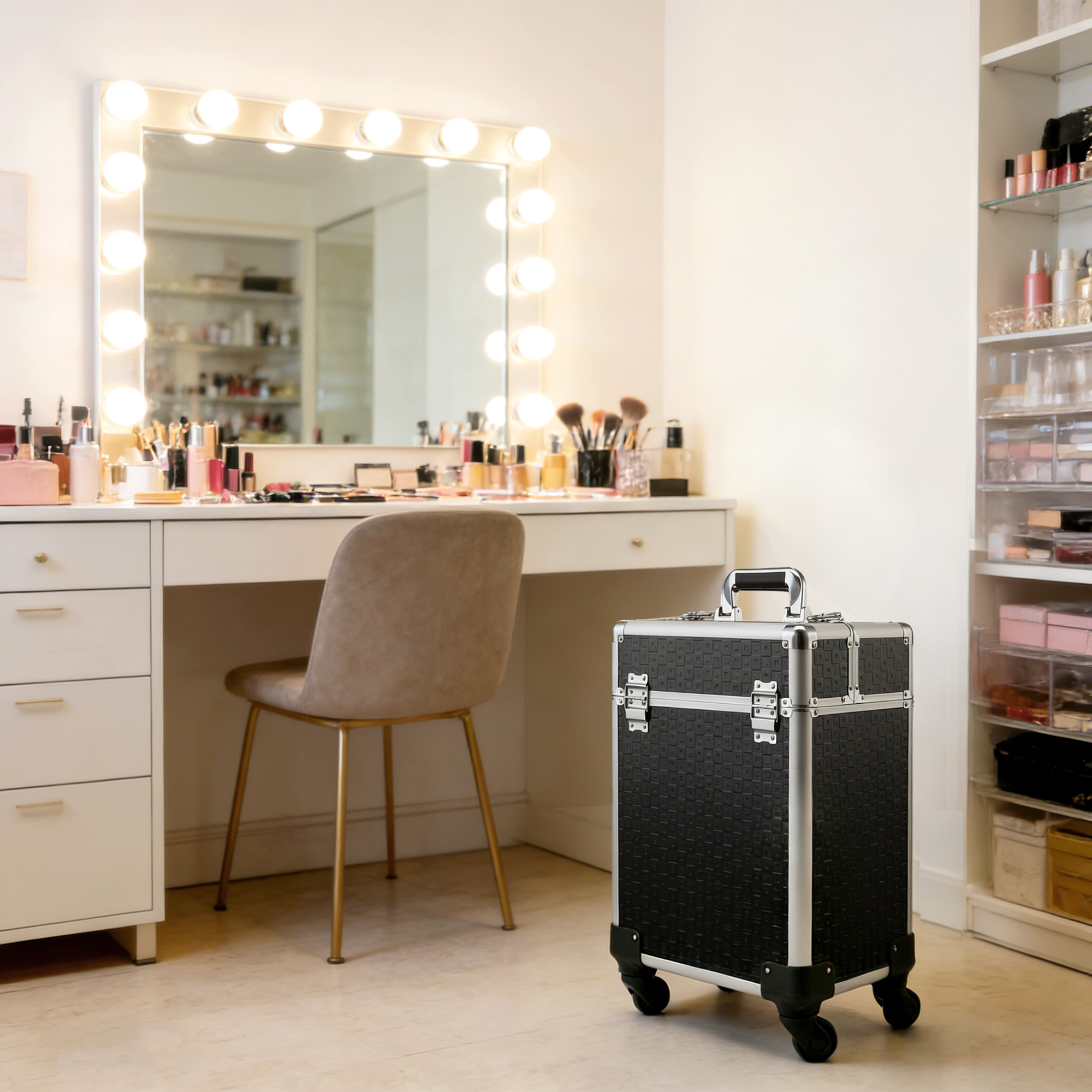 Un maletín de maquillaje negro con ruedas se encuentra en una habitación luminosa frente a un tocador.