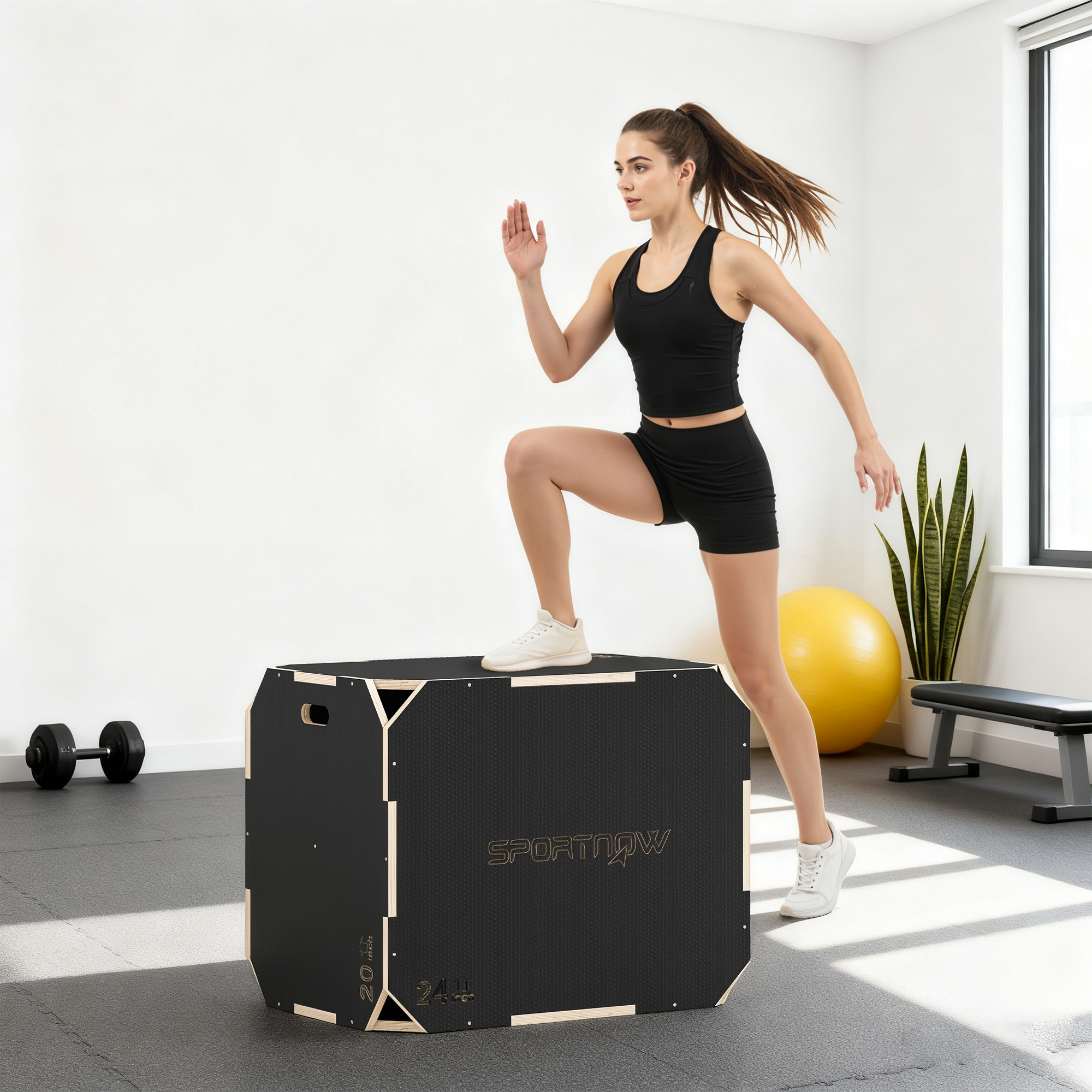 Una mujer con ropa deportiva negra sube a un cajón pliométrico en un gimnasio luminoso.