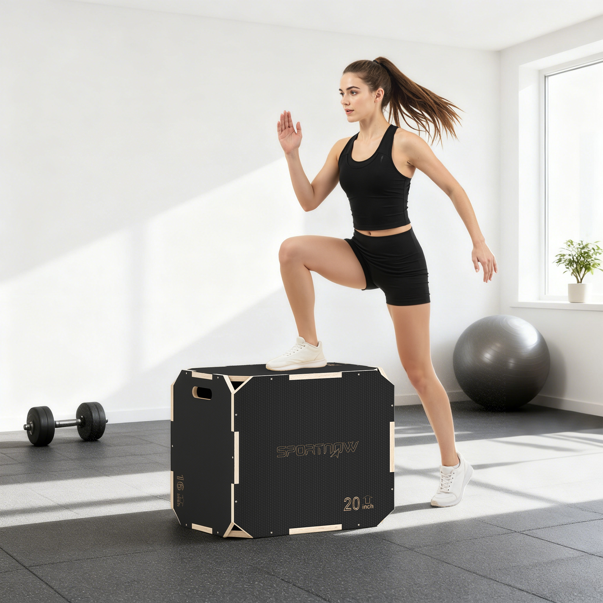Una mujer en ropa deportiva sube a un cajón pliométrico negro en un gimnasio.