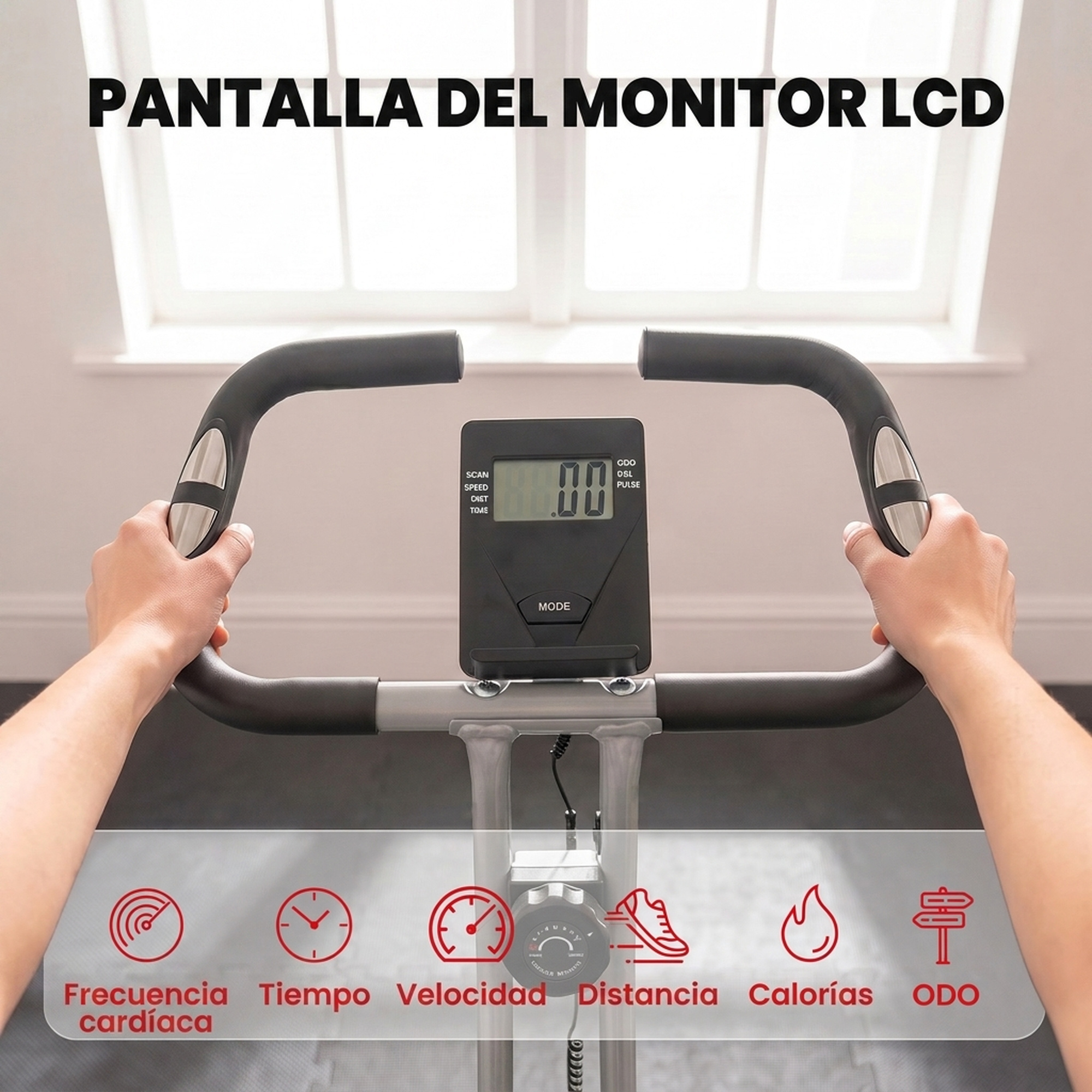 Una persona sostiene el manillar de una bicicleta estática con un monitor LCD frente a una ventana.