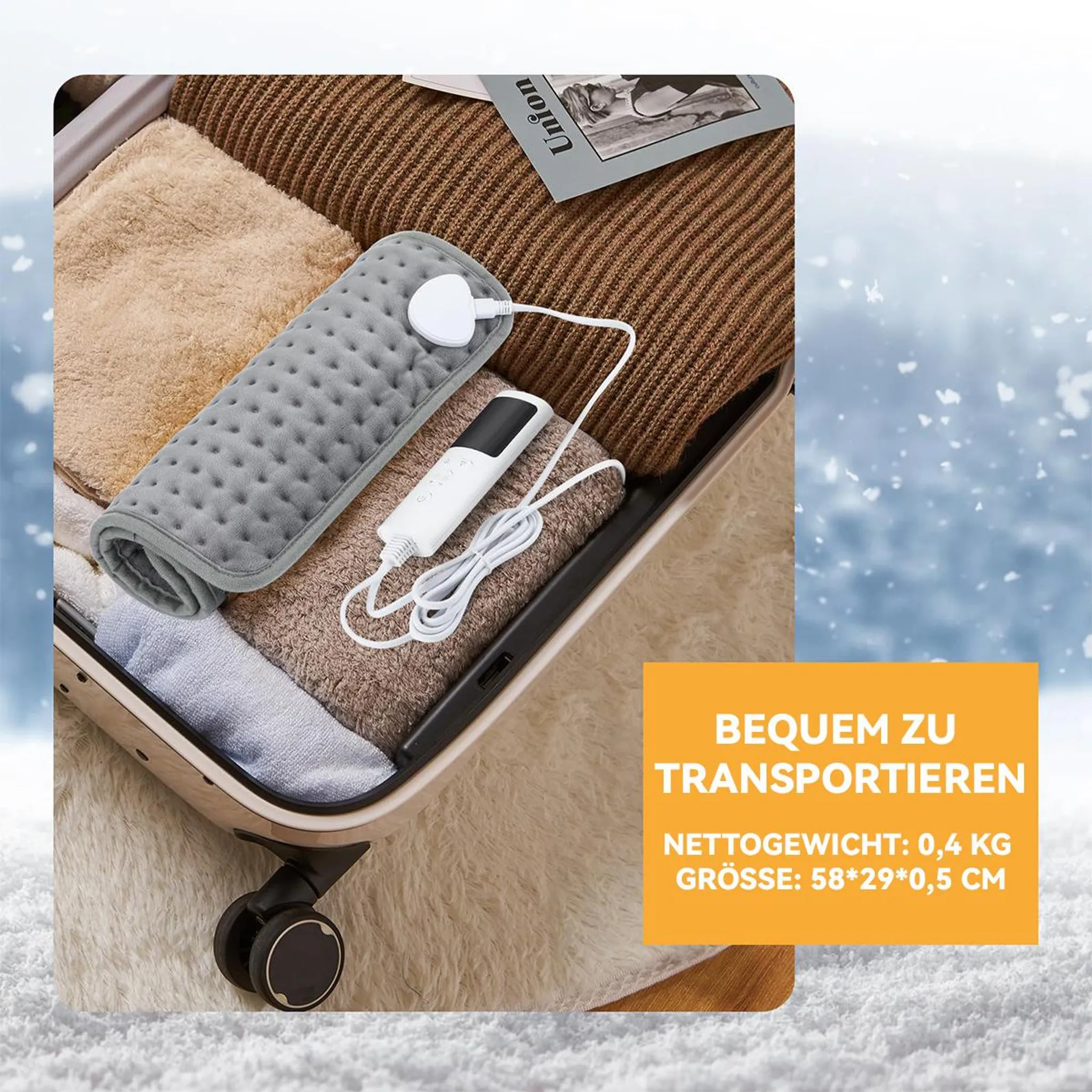 Eine graue, gerollte Heizdecke und Kleidung in einem Koffer auf schneebedecktem Hintergrund.