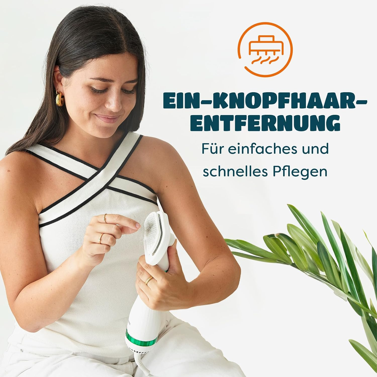 Eine Frau entfernt Haare von einer Bürste mit deutscher Aufschrift vor weißem Hintergrund.