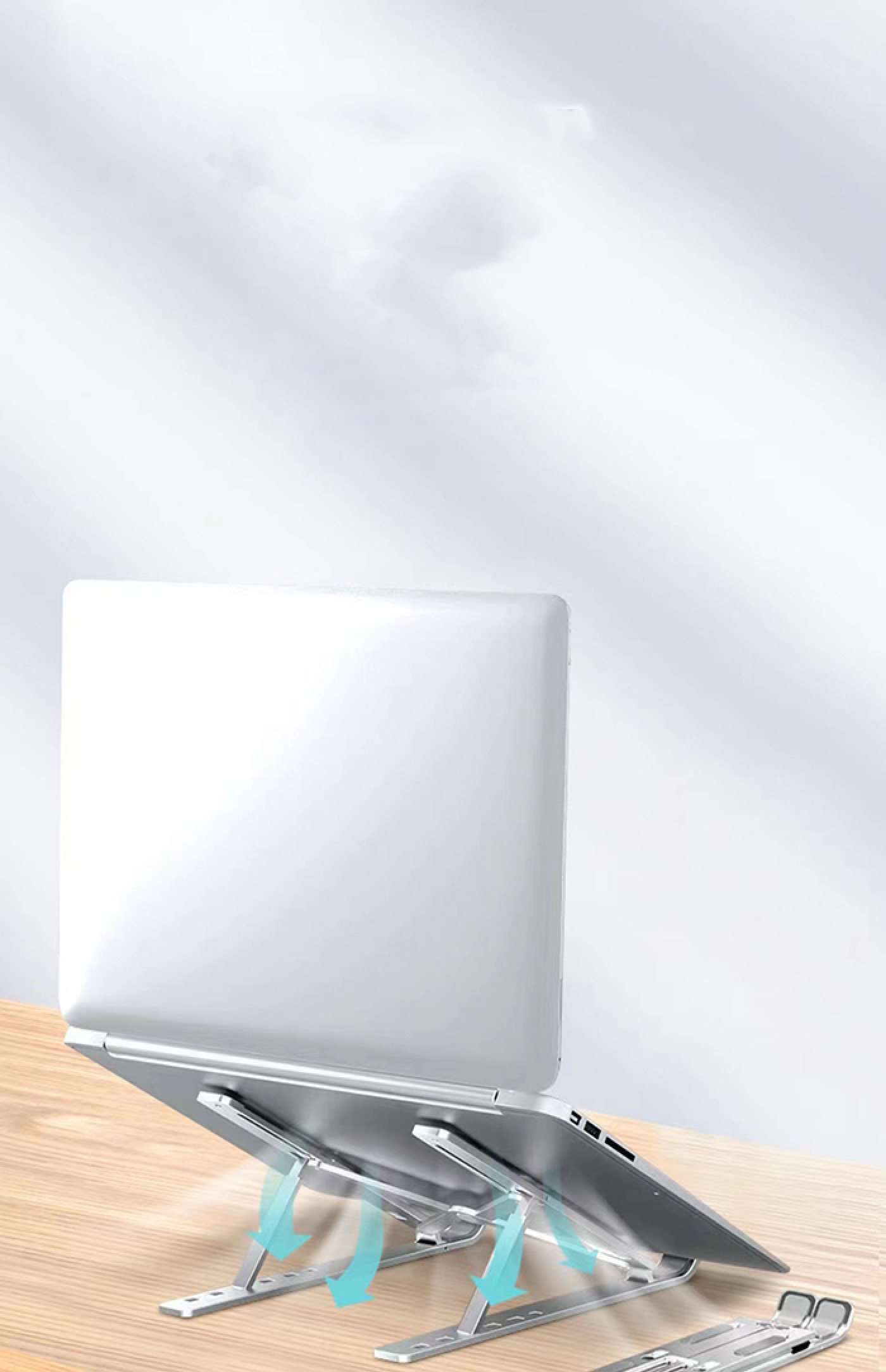 Ein silberner Laptop auf einem verstellbaren Ständer aus Metall auf einem Holztisch vor einem verschwommenen Hintergrund.
