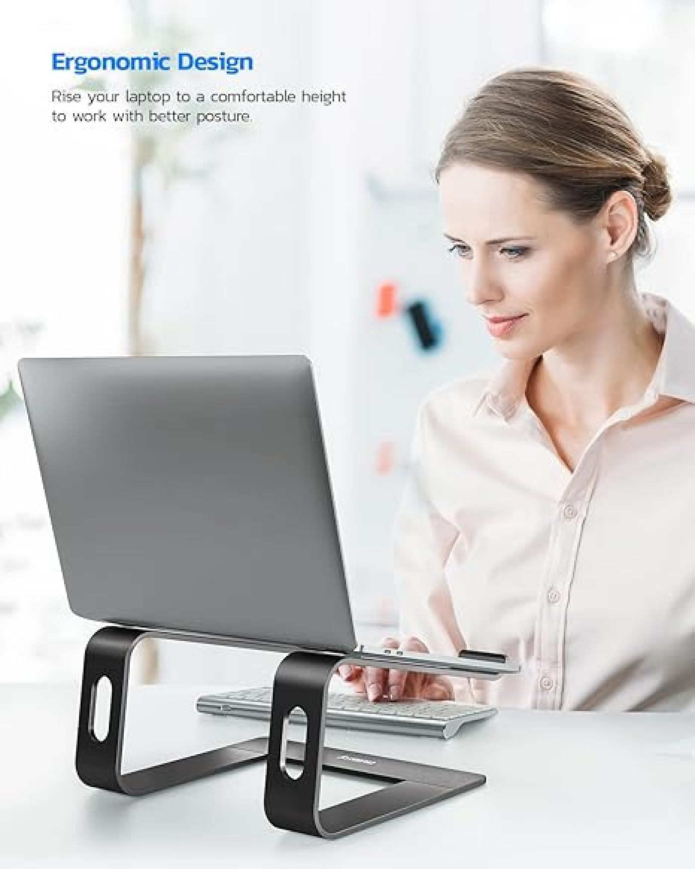 Eine Frau arbeitet an einem Laptop, der auf einem schwarzen Ständer steht.