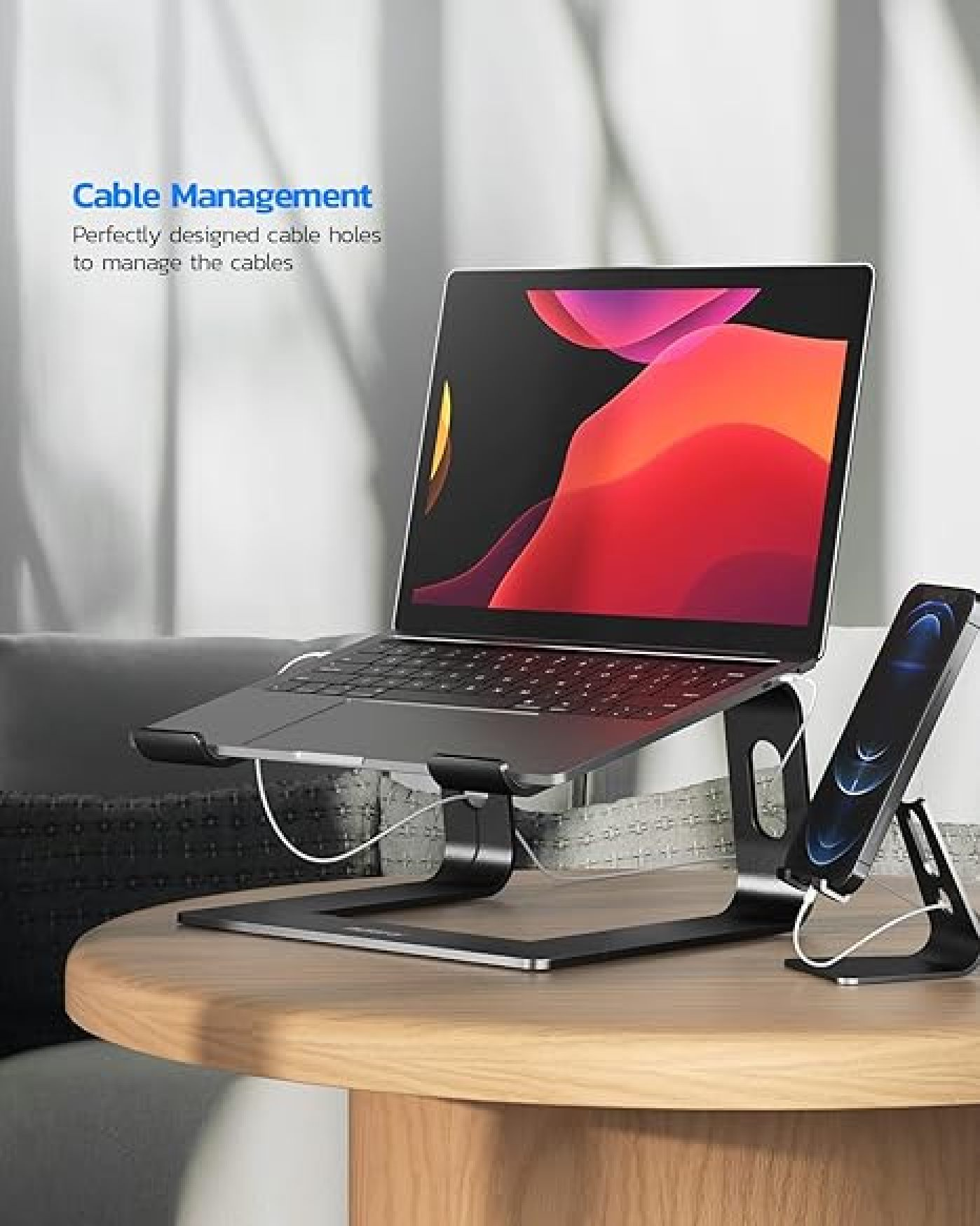 Ein Laptop und ein Telefon auf schwarzen Metallständern auf einem Holztisch, mit Text zum Kabelmanagement.