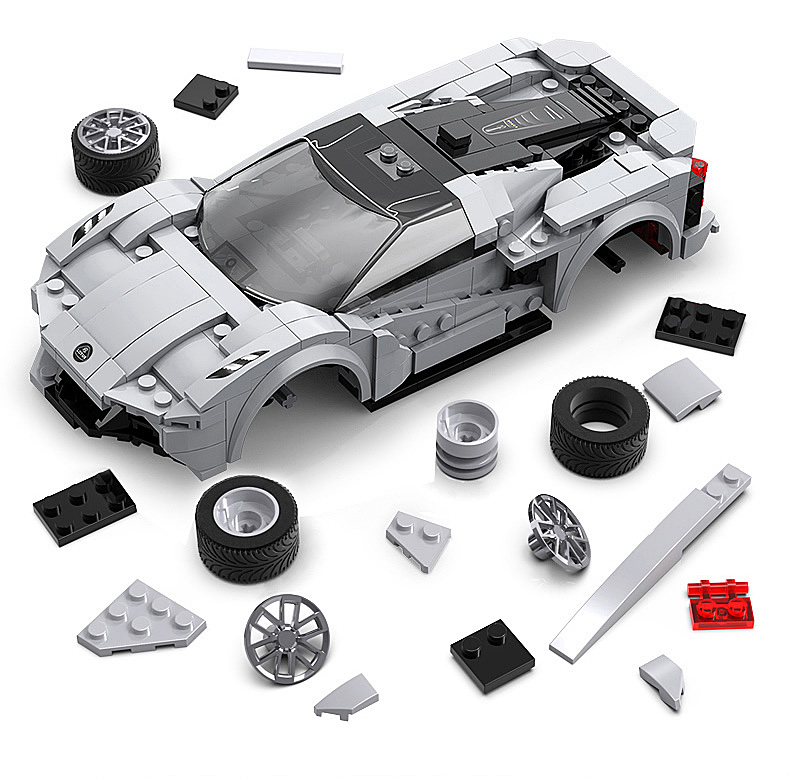 Ein teilweise zusammengebauter grauer Lego Sportwagen umgeben von losen Steinen und Reifen auf weißem Hintergrund.