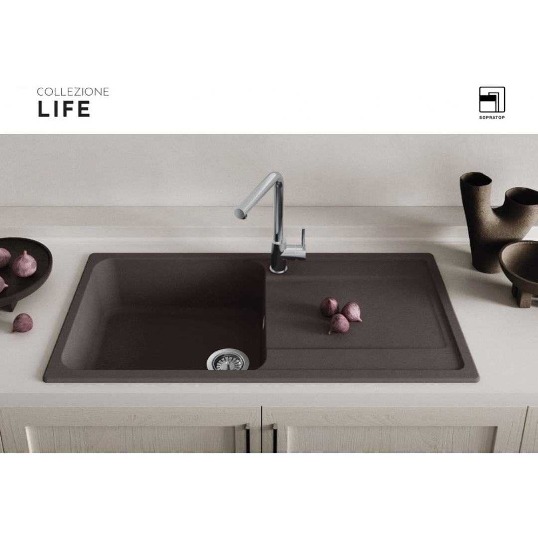 Lavello da cucina marrone scuro con rubinetto moderno e fichi sul piano di lavoro in una cucina luminosa.