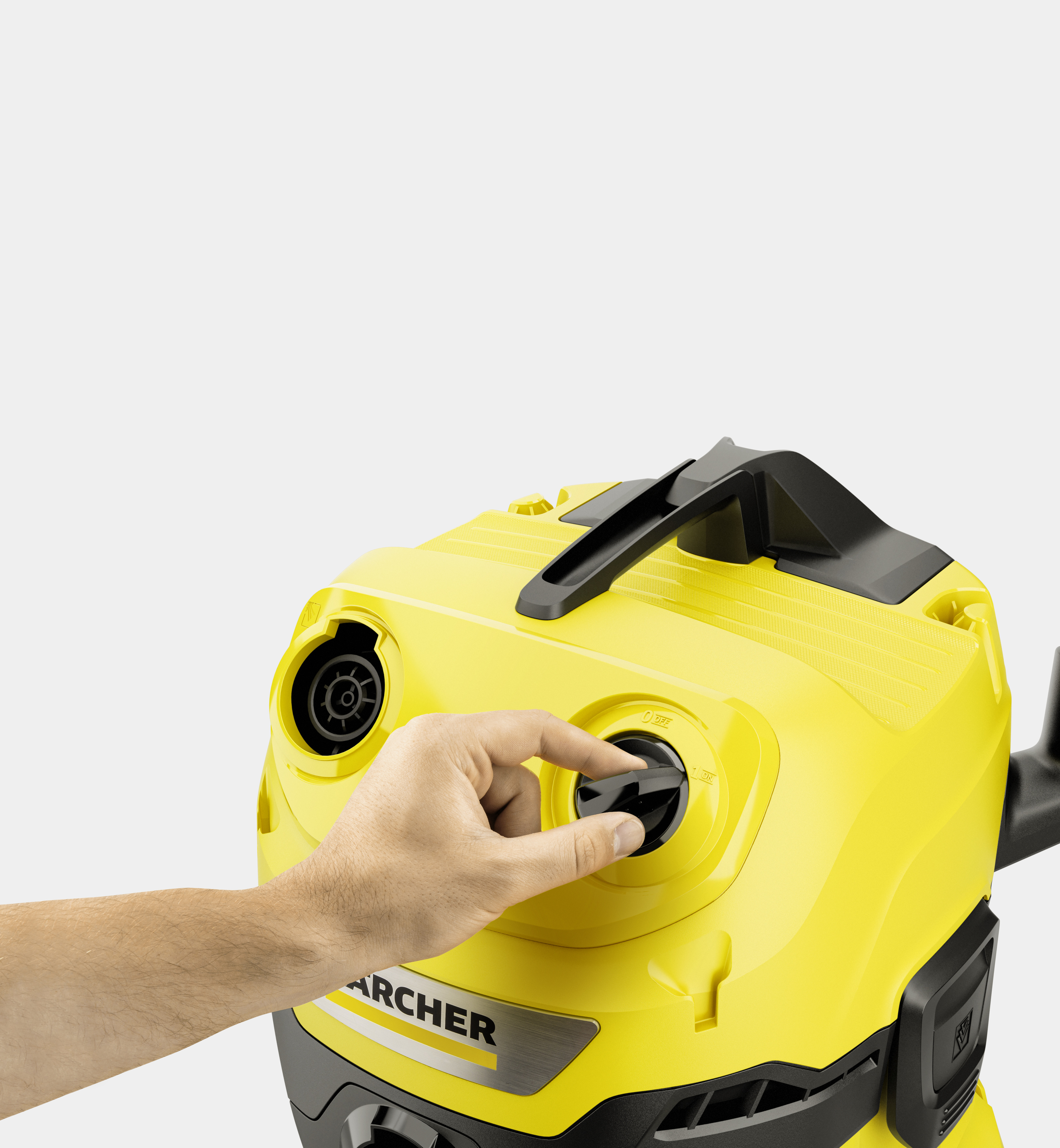 Una mano gira la manopola di accensione nera su un aspirapolvere Karcher giallo su sfondo grigio.