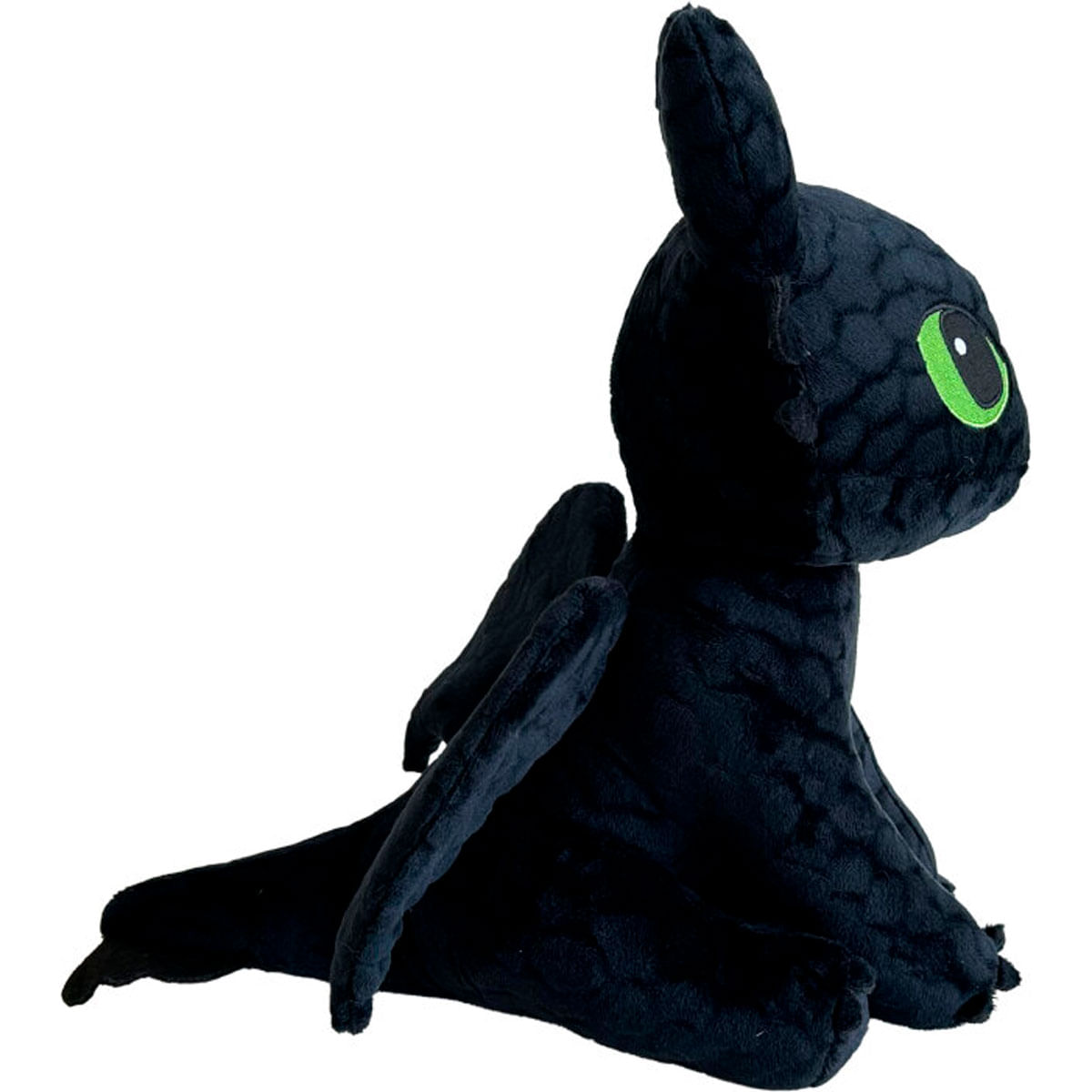Un juguete de peluche de dragon negro con grandes ojos verdes y alas pequenas sentado sobre un fondo blanco.