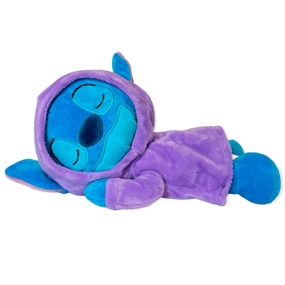 Un peluche azul de Stitch con sudadera con capucha morada yace de lado, durmiendo.