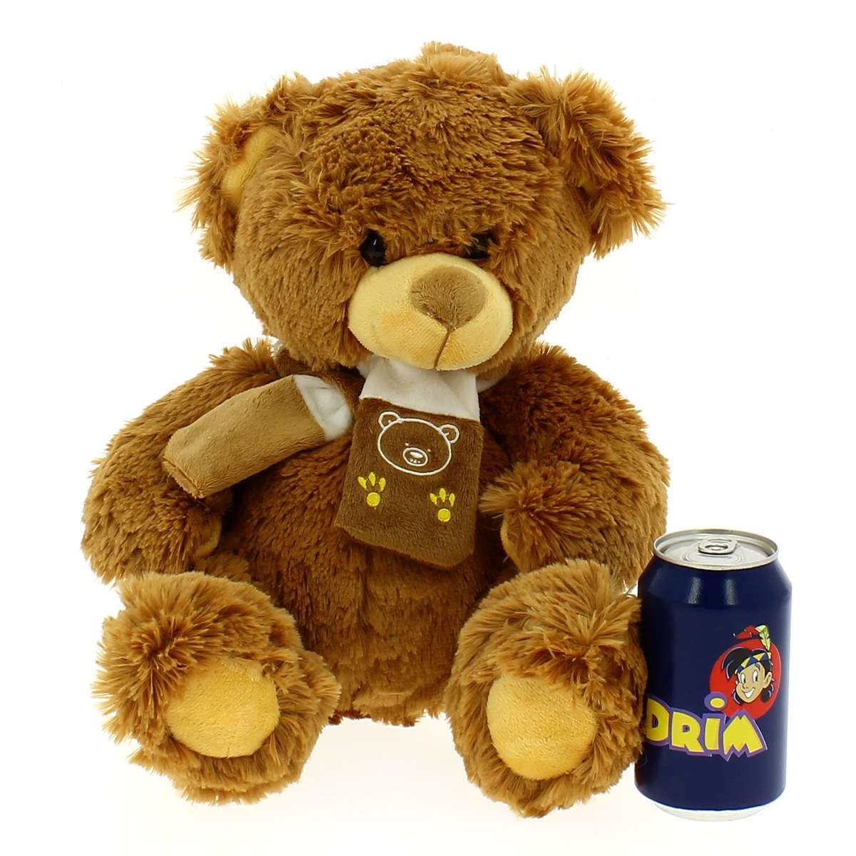 Un osito de peluche marrón sentado junto a una lata de refresco azul sobre fondo blanco.