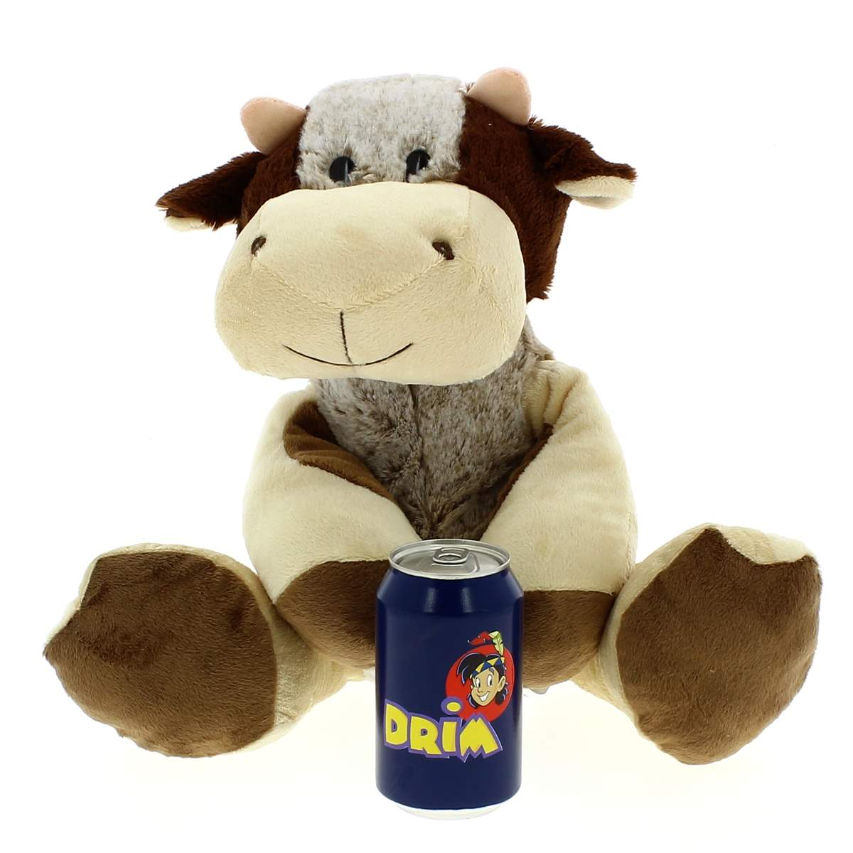 Un peluche de vaca marrón y blanca sentado sobre un fondo blanco con una lata de refresco azul delante.