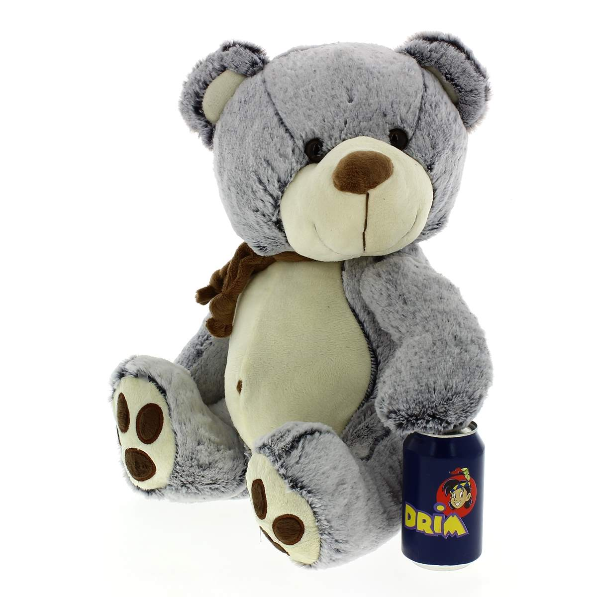 Un osito de peluche gris con bufanda marrón y panza clara se sienta junto a una lata azul.