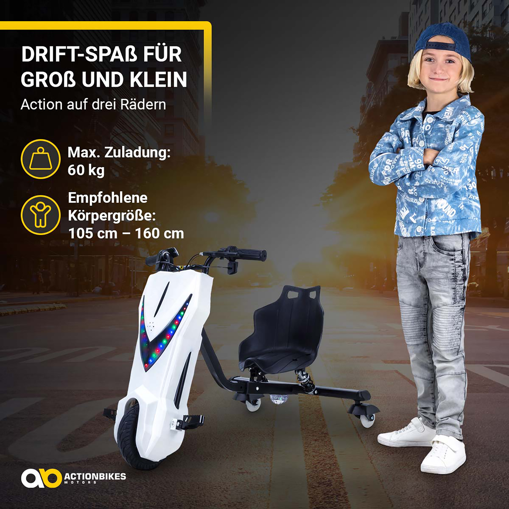 Ein Kind in Jeanskleidung steht stolz neben einem dreirädrigen Elektro-Drifttrike vor einer Stadtkulisse.