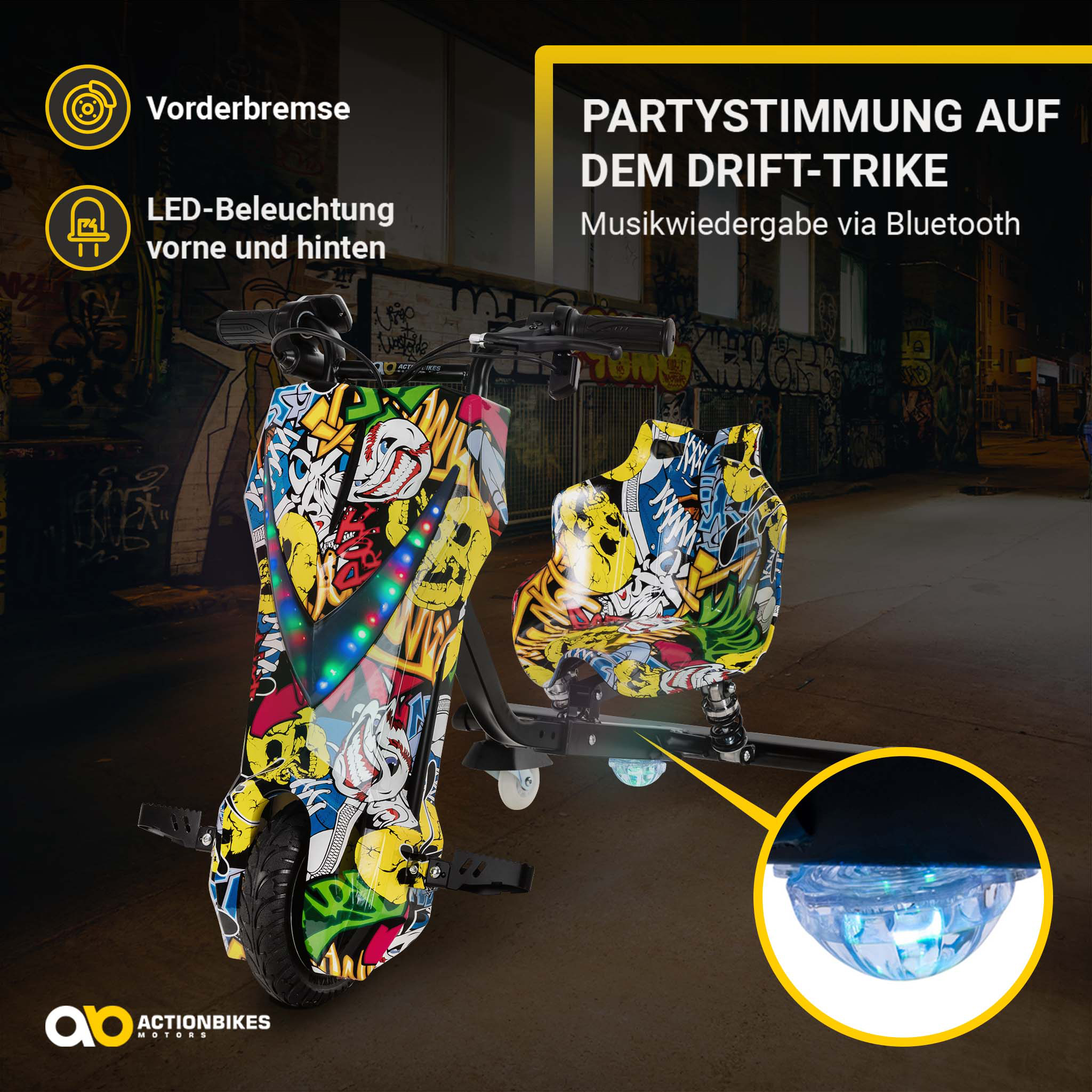 Ein graffiti-bedrucktes Drift-Trike mit LED-Lichtern und Bluetooth vor einer Backsteinwand.