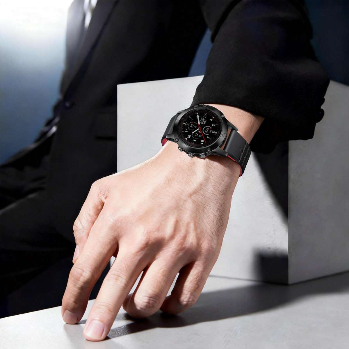 Eine Person im schwarzen Anzug trägt eine schwarze Smartwatch mit rotem Akzent am Handgelenk.