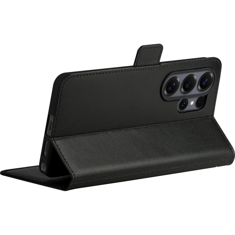 Ein schwarzes Smartphone in einer Lederklapphülle, die als Ständer auf einer weißen Oberfläche dient.