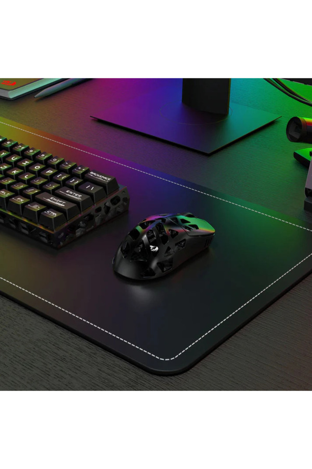 RGB aydınlatmalı masa matı üzerinde siyah petek desenli oyuncu mouse ve klavye.