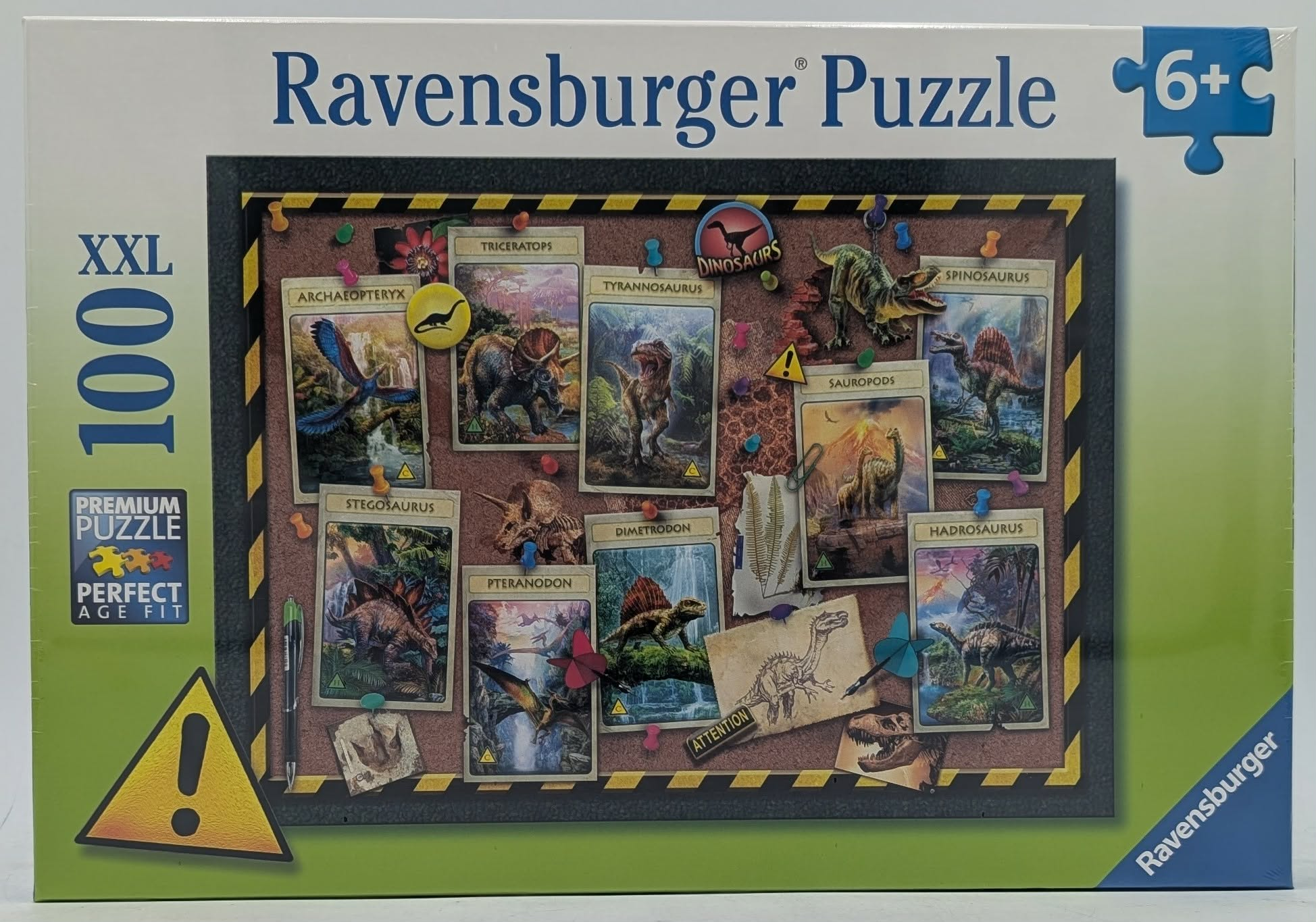 Scatola di puzzle di dinosauri Ravensburger con carte di varie specie su una bacheca.