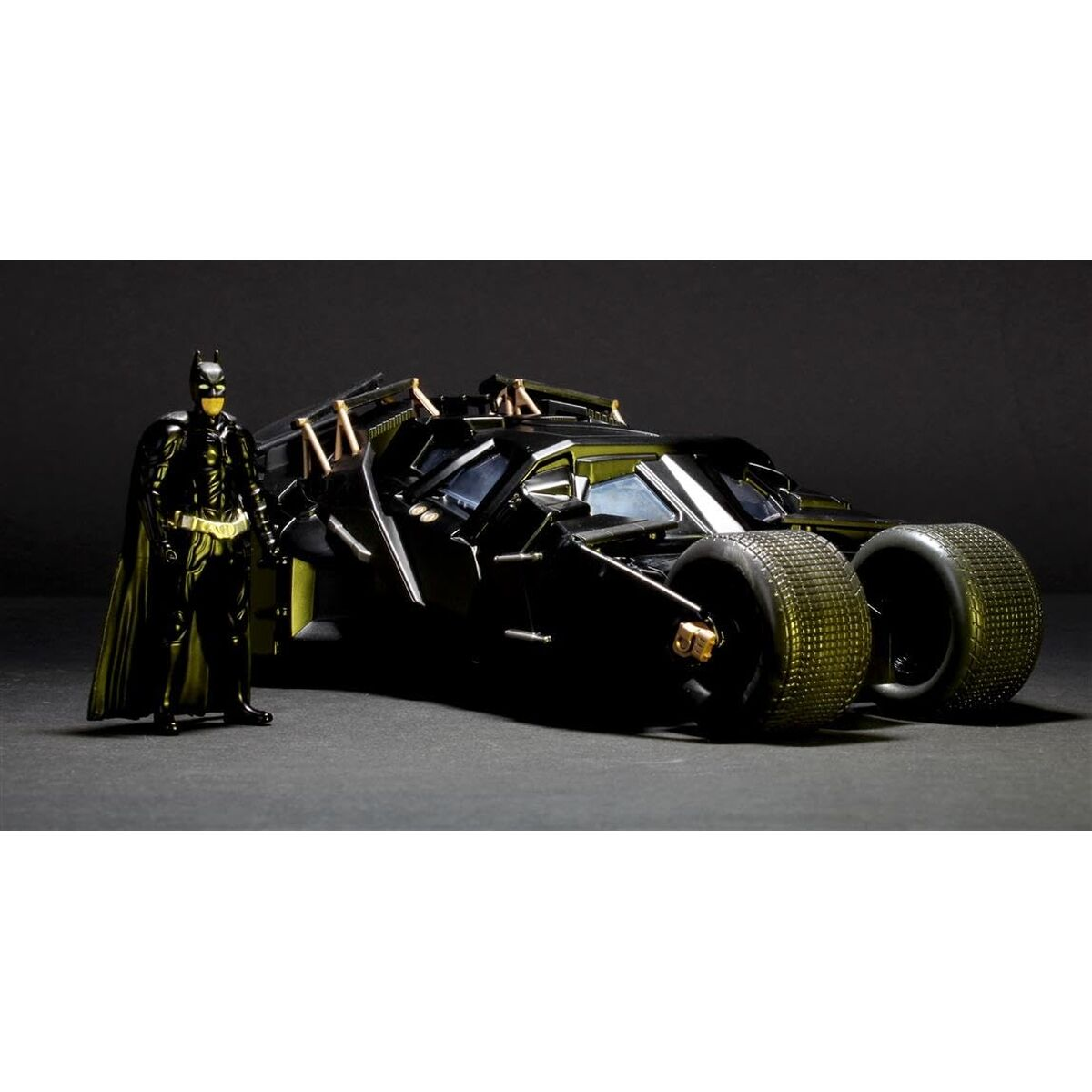 Una figura de acción de Batman negra se encuentra junto al Batmóvil blindado sobre un fondo oscuro.