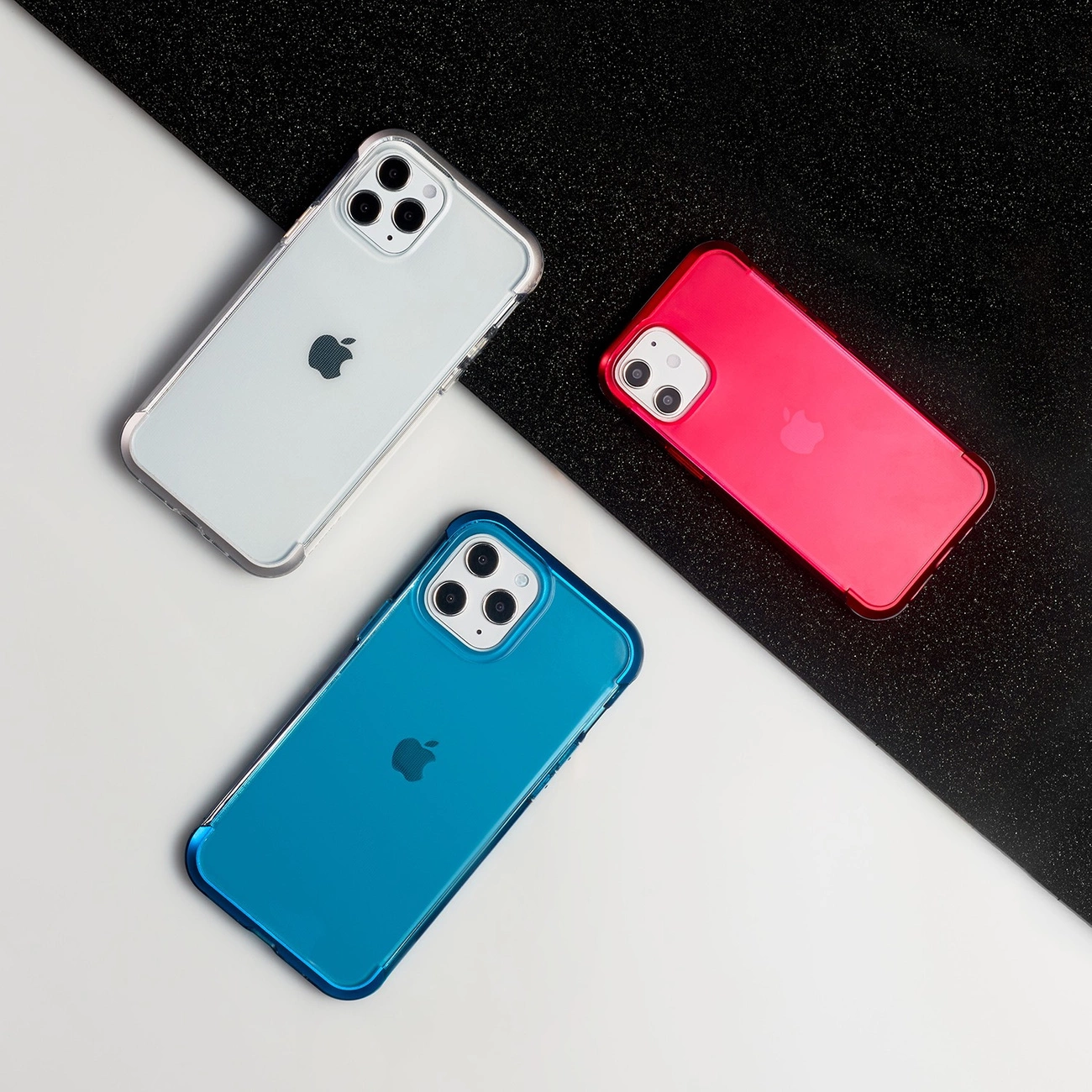 Tre smartphone in cover bianca, blu e rossa su uno sfondo diviso diagonalmente in bianco e nero.