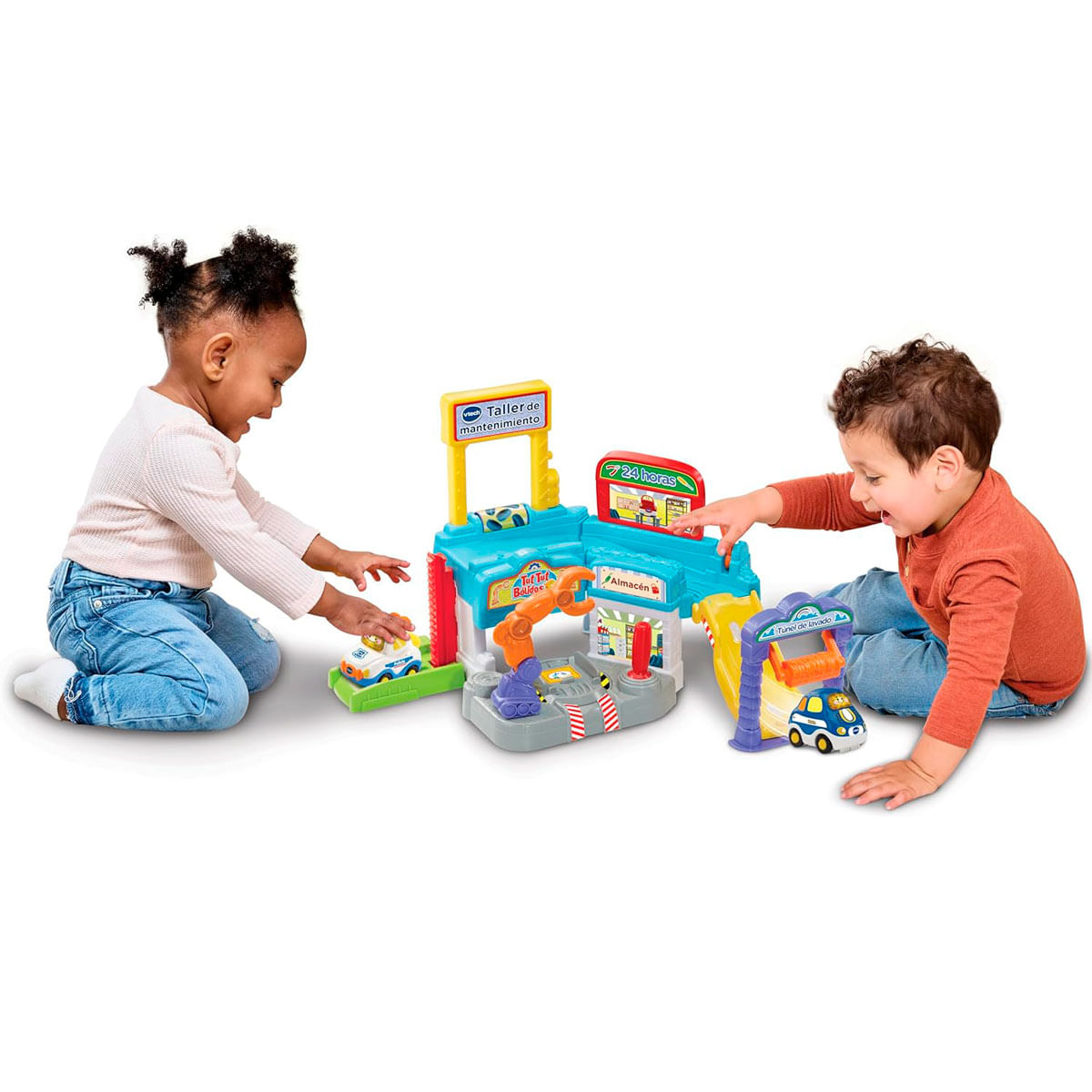 Dos niños pequeños juegan felices juntos en el suelo con un colorido garaje de juguetes.