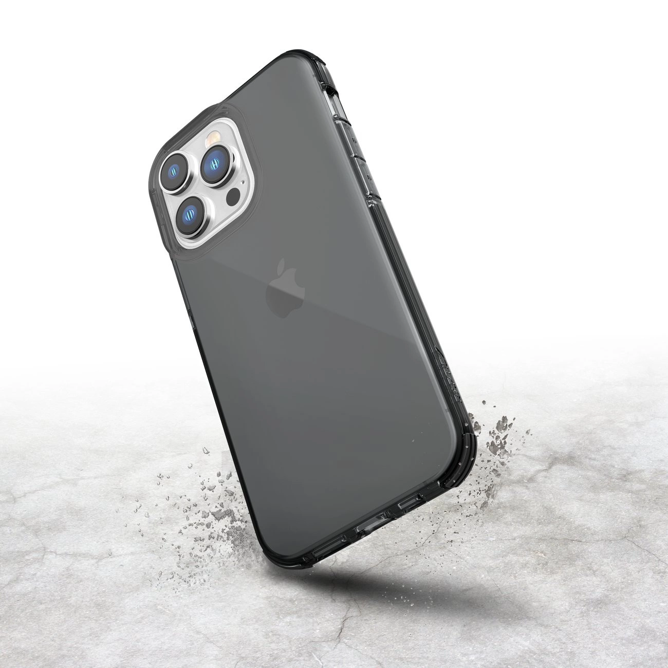 Uno smartphone in una custodia trasparente sospeso su una superficie di cemento grigio con detriti.