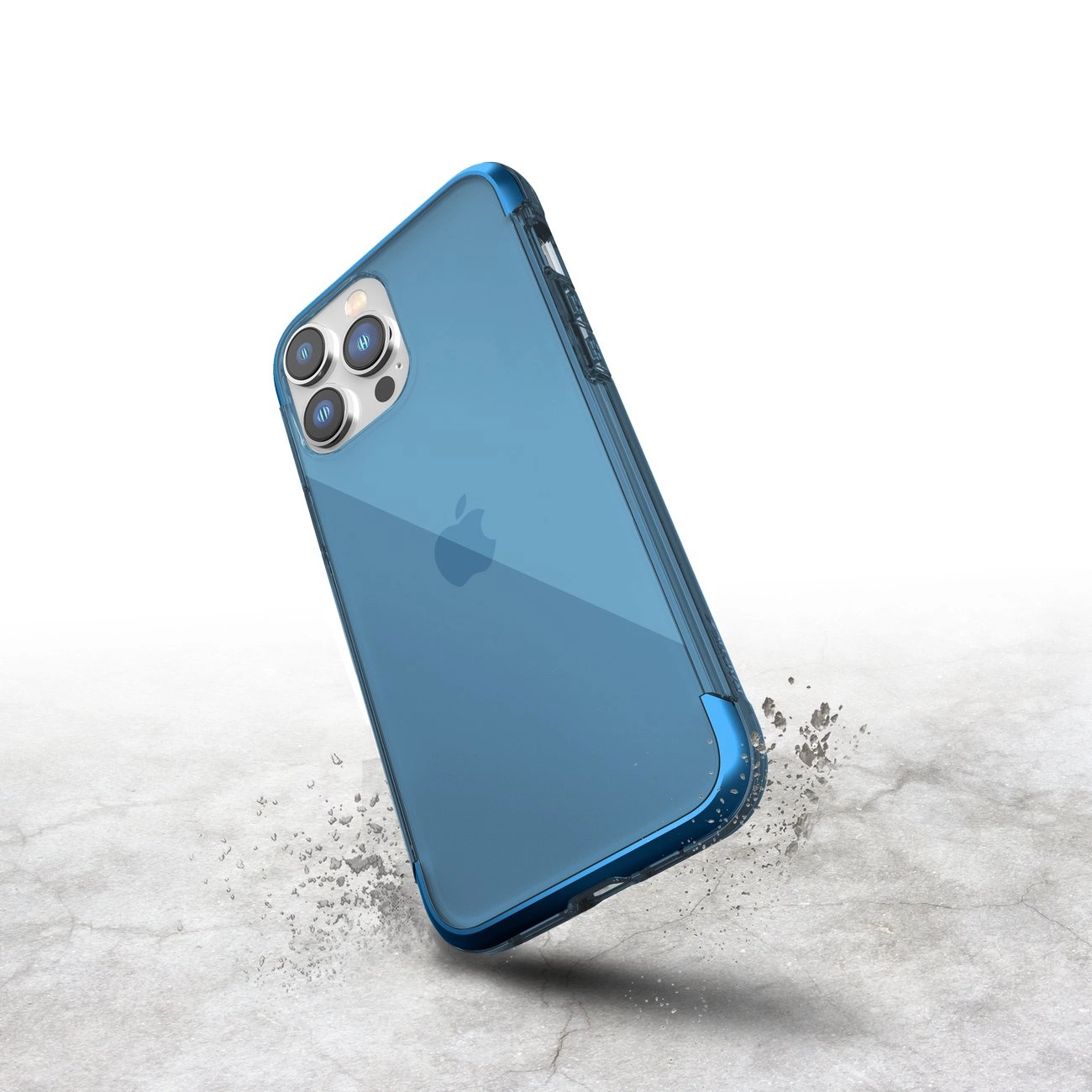 Uno smartphone blu con cover cade su un pavimento in cemento, circondato da detriti.