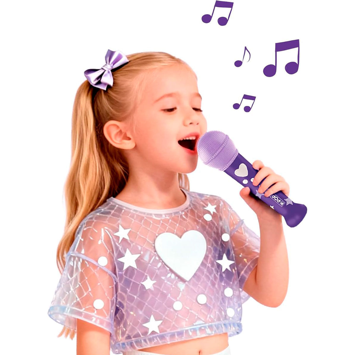 Una niña rubia con una blusa brillante canta en un micrófono de juguete morado.