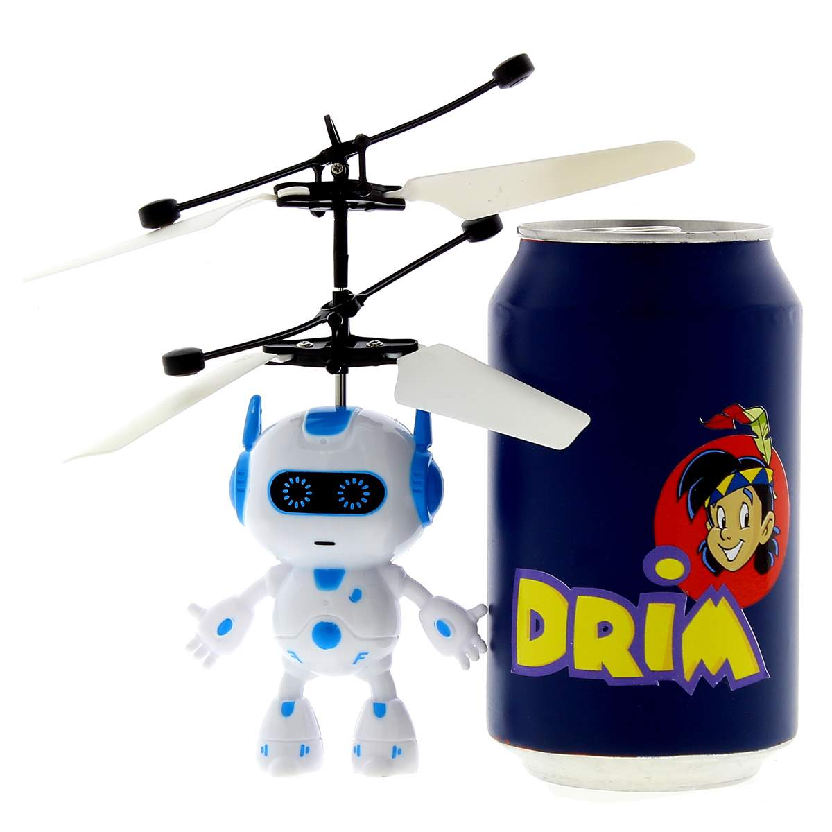 Un pequeño robot de juguete blanco y azul con hélices de helicóptero junto a una lata de refresco azul.