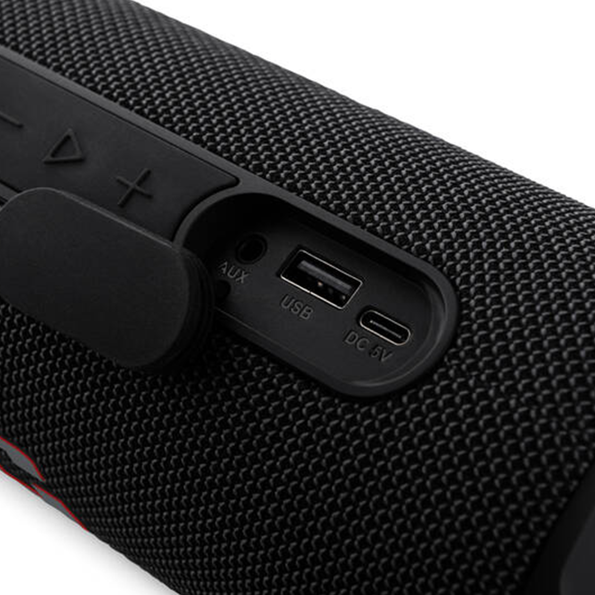 Zblizenie czarnego bezprzewodowego glosnika z portami AUX, USB i DC 5V pod otwarta gumowa oslona.
