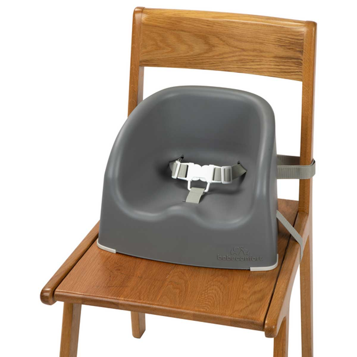 Asiento elevador para bebé gris con arnés de seguridad en silla de madera.