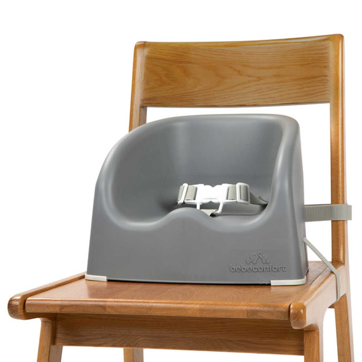 Asiento elevador para bebé gris con correas, colocado en una silla de madera.