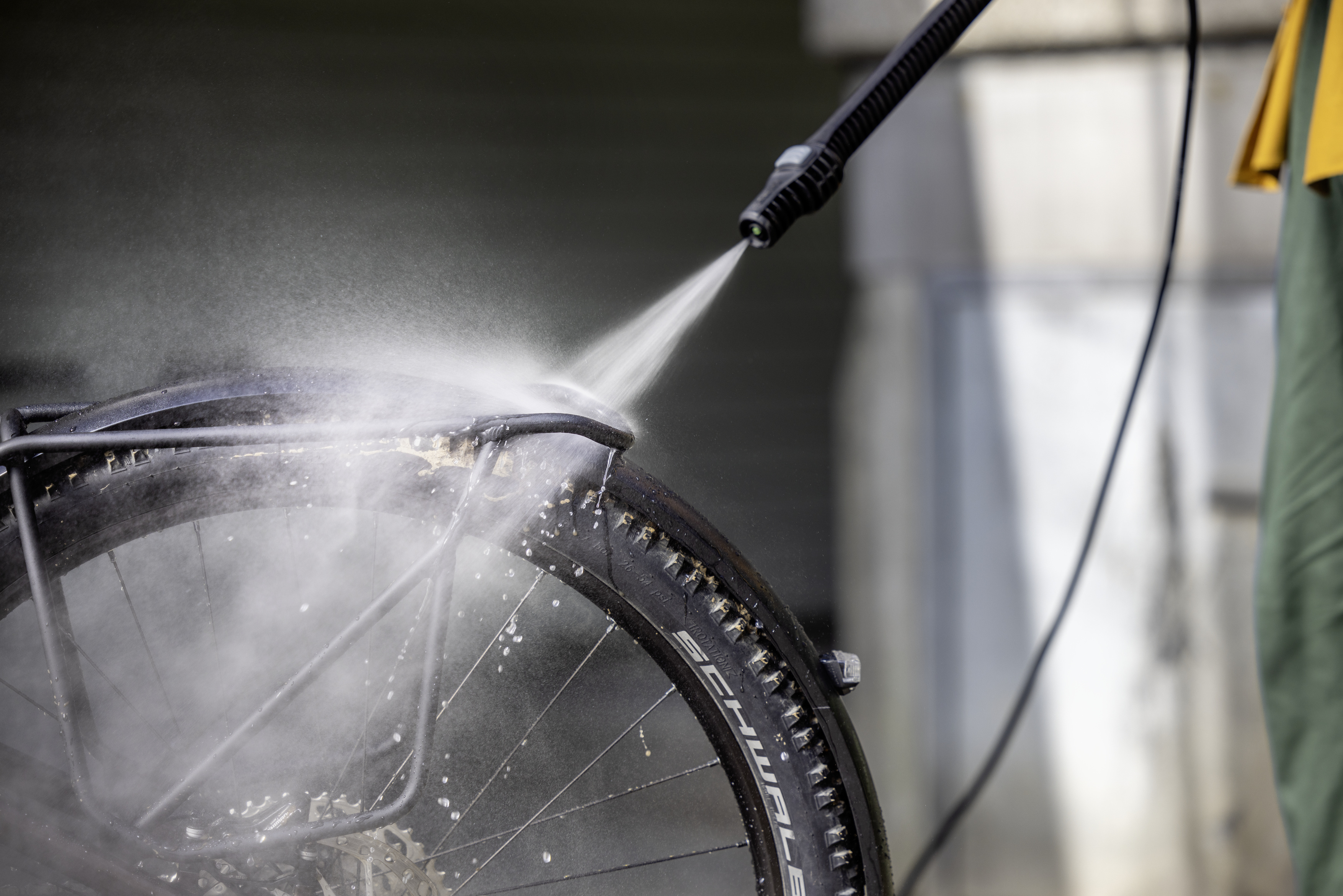 Una gomma di bicicletta viene pulita dallo sporco con un idropulitrice.