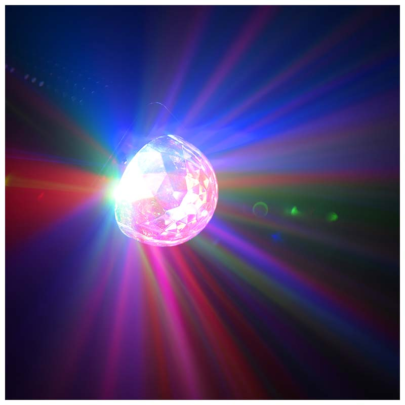 Eine facettierte, glänzende Kugel strahlt helles pinkes, blaues und rotes Licht in einem dunklen Raum aus.