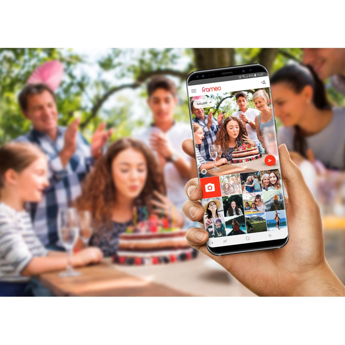 Hand houdt smartphone met foto-app vast, met feestende familie op de achtergrond.