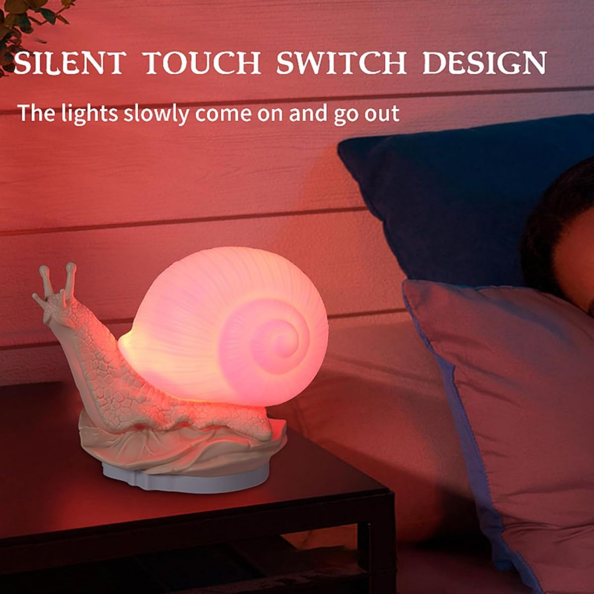 Eine rosafarbene schneckenförmige Nachtlampe leuchtet auf einem Nachttisch im Schlafzimmer.