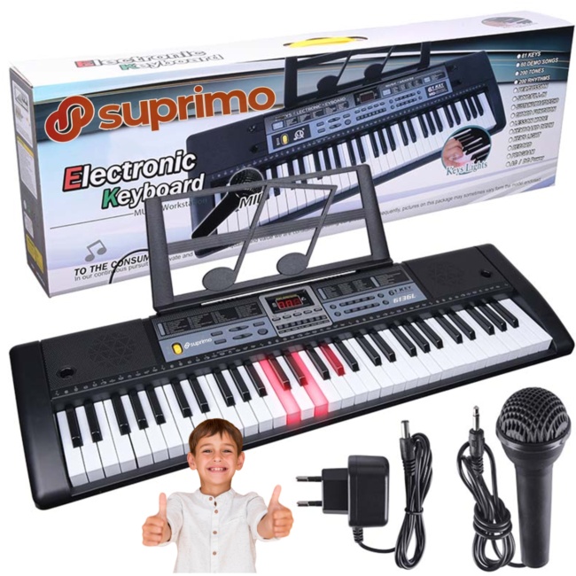 Ein Kinder-Elektronik-Keyboard von Suprimo mit Ständer, Mikrofon und Netzteil vor einer Verpackung und einem glücklichen Jungen.