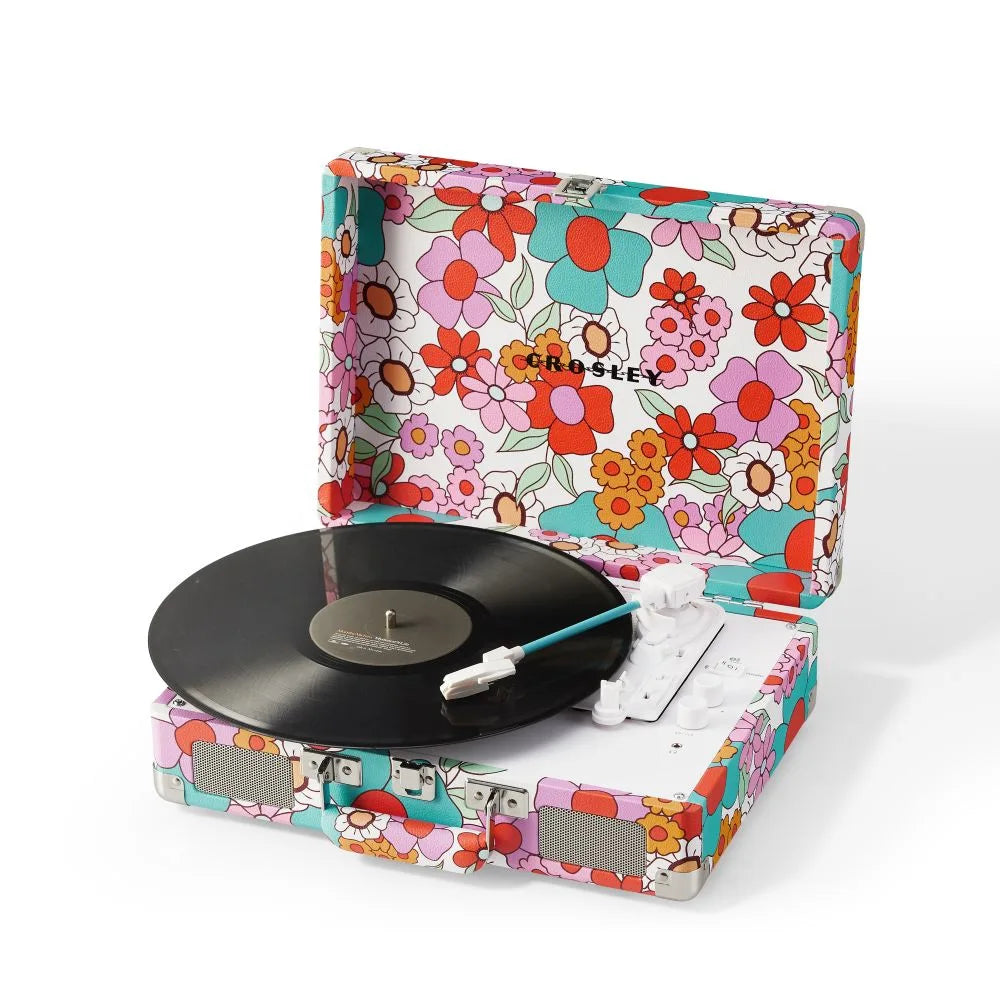 Ein tragbarer Retro-Plattenspieler mit bunten Blumenmustern, schwarzer Schallplatte und weißen Lautsprechern.