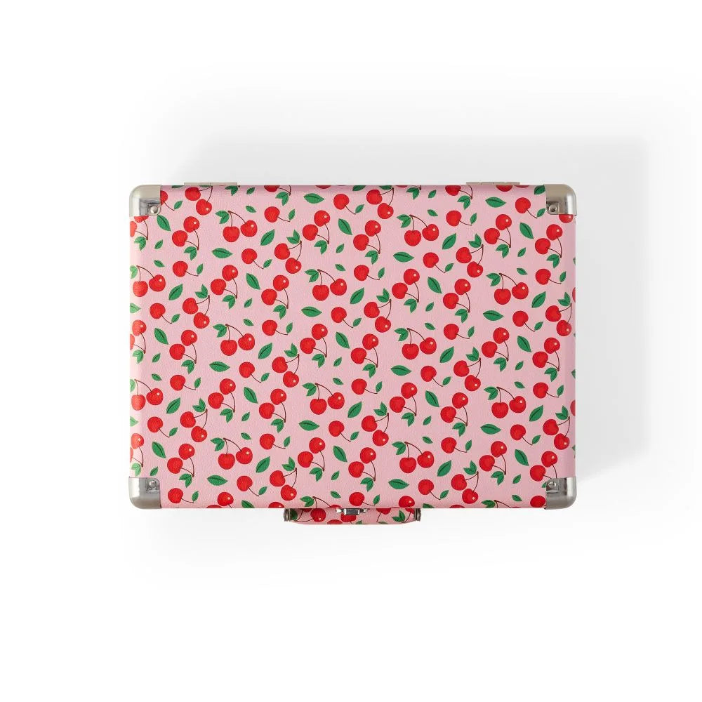 Ein rechteckiger Koffer mit einem Muster aus roten Kirschen und grünen Blättern auf rosa Hintergrund.