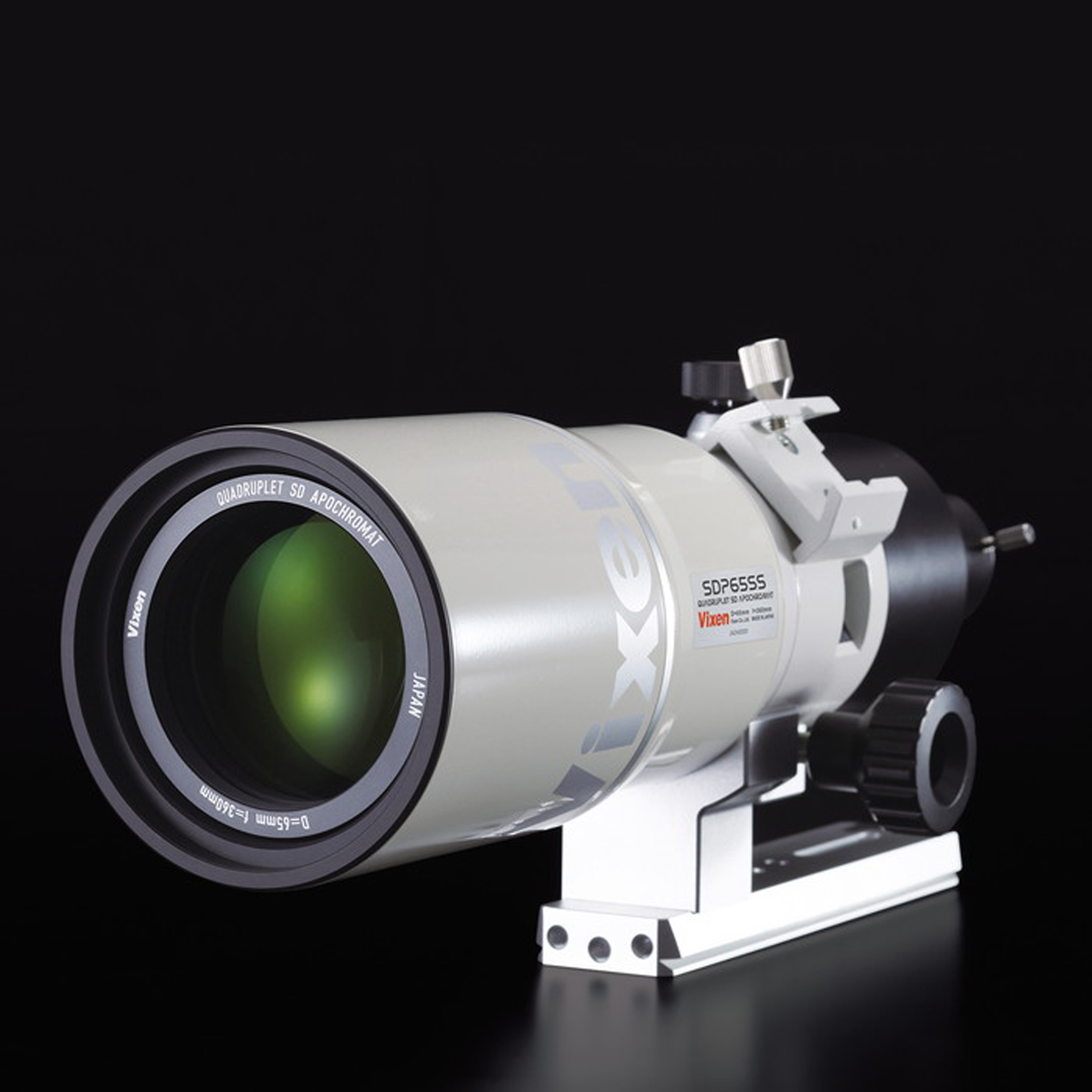 Una lente de telescopio Vixen SDP65SS blanca sobre fondo negro, con un gran elemento de cristal.