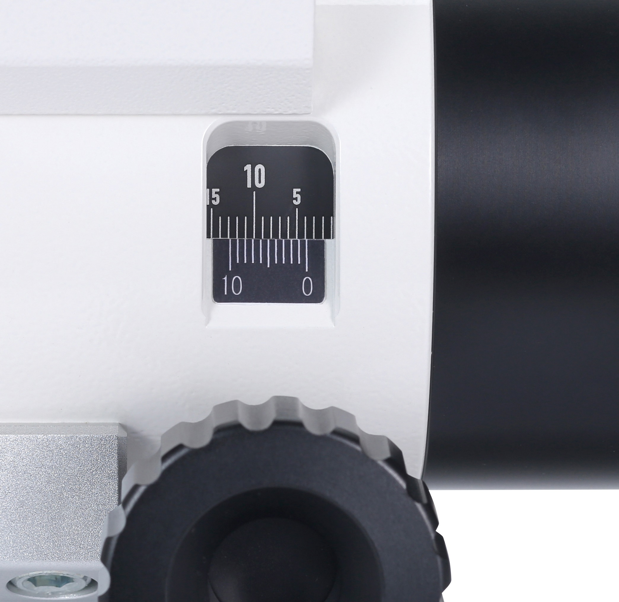 Primer plano de una escala de medición con números y una perilla de ajuste negra en un dispositivo blanco y negro.