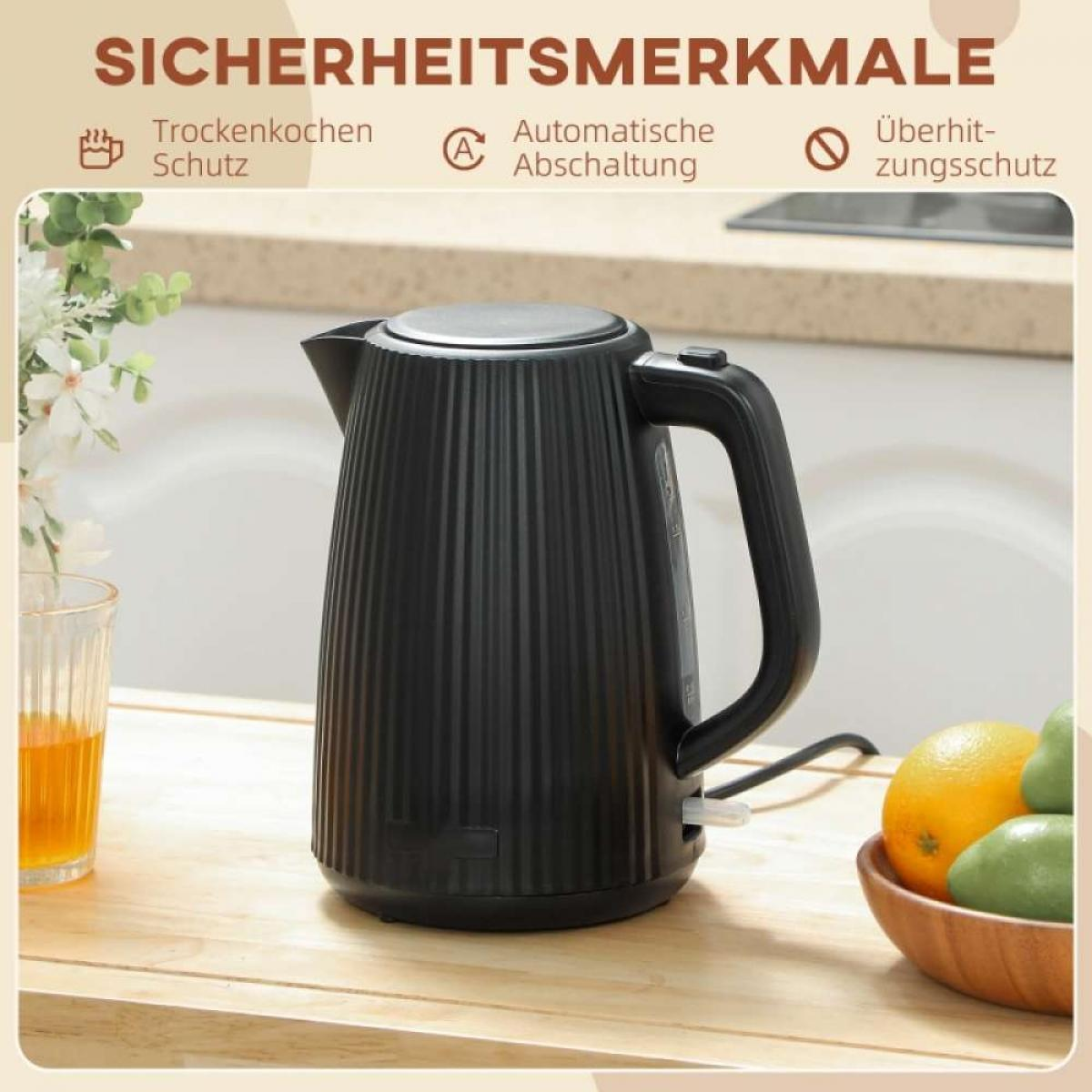 Schwarzer gerippter Wasserkocher auf Holztisch mit Früchten und Blumen im Hintergrund.