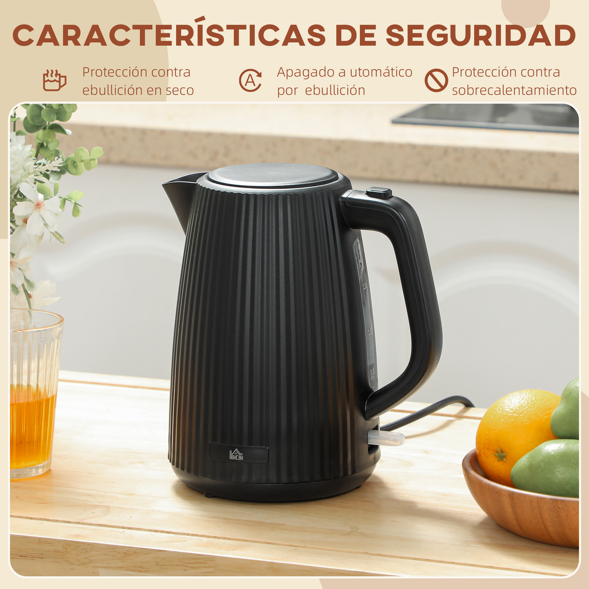 Un hervidor eléctrico negro ranurado sobre una encimera de madera con un vaso de zumo y fruta.