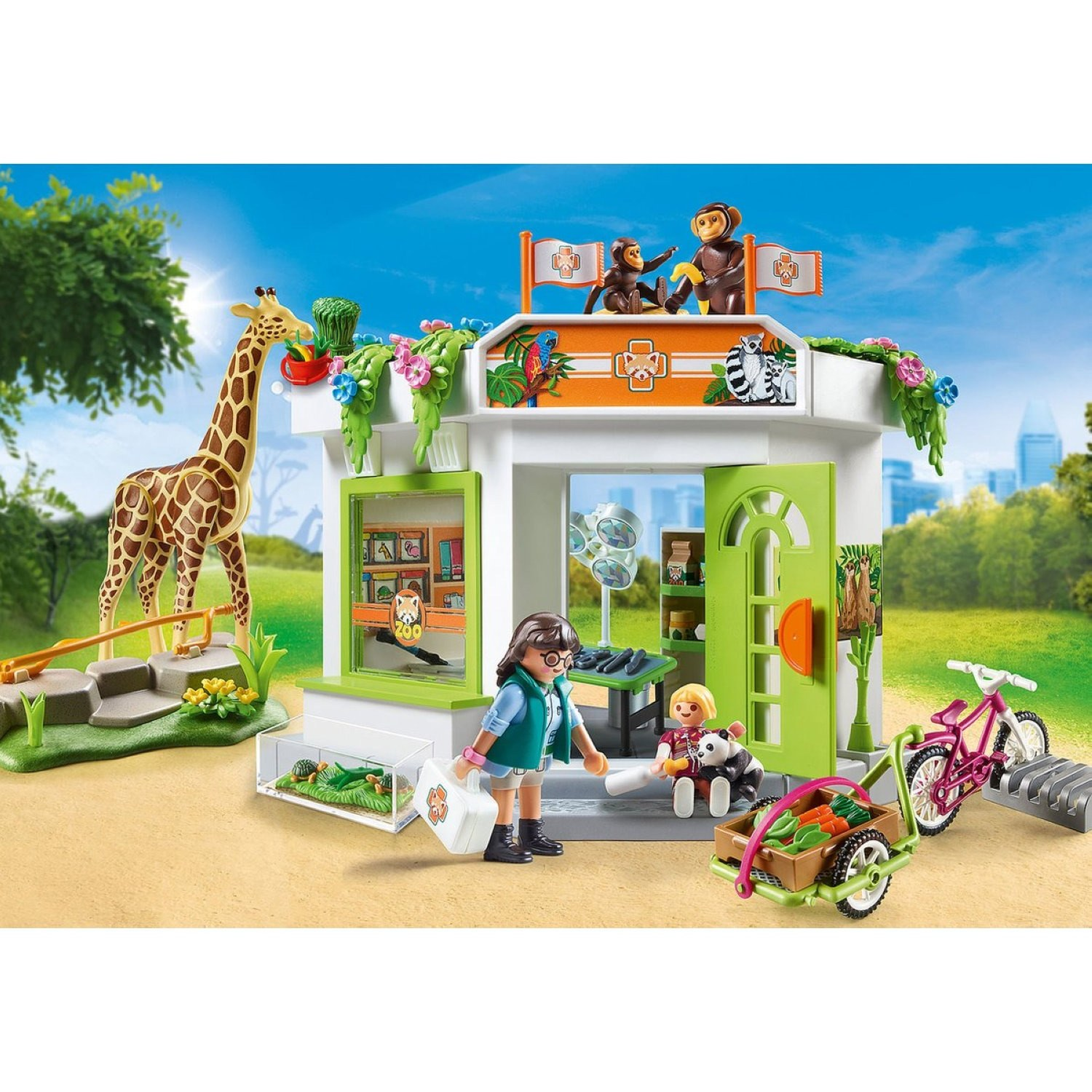 Stazione veterinaria dello zoo Playmobil con personaggi, giraffa, scimmie e accessori in un paesaggio verde.