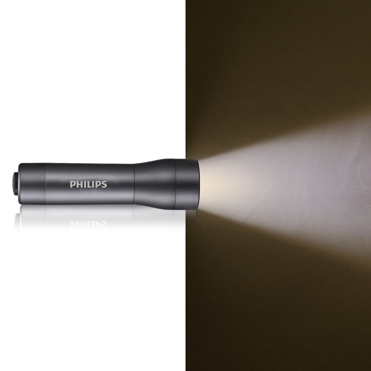 Una torcia grigia Philips si trova su una superficie bianca, proiettando un fascio di luce a destra su uno sfondo scuro.