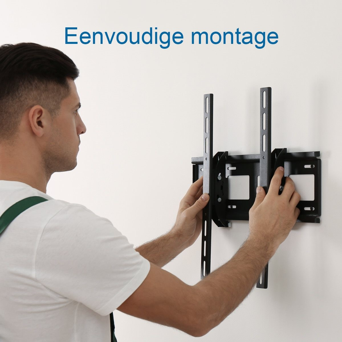 Un homme en t-shirt blanc installe un support TV noir sur un mur blanc. Le texte Eenvoudige montage est visible.